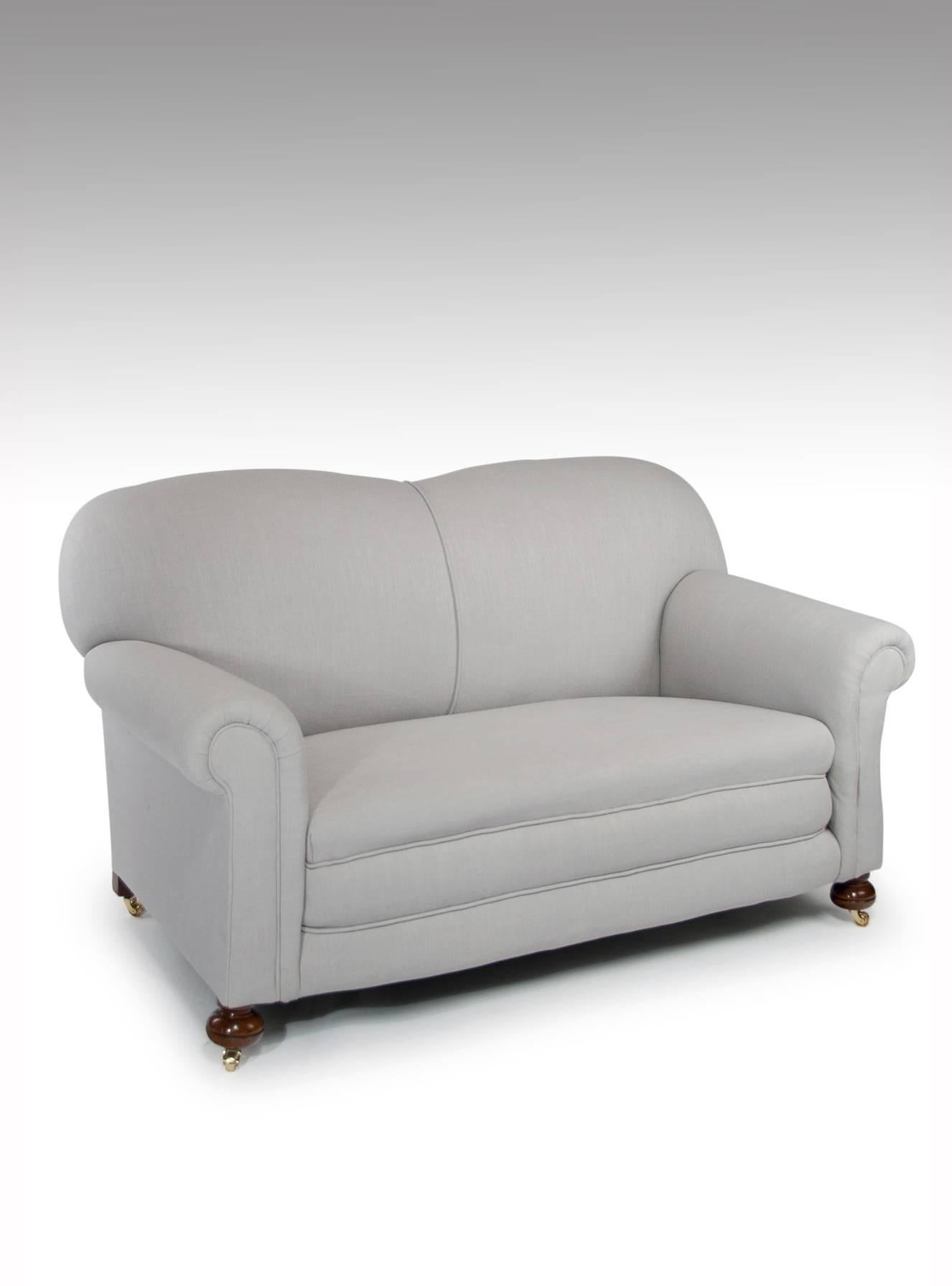 A good quality and well-proportioned Victorian drop arm settee/sofa newly reupholstered in a grey linen.
Having a shaped back with and scrolled arms and piped edge the right hand arm drops via a ratchet to various stages down to level. The sofa has