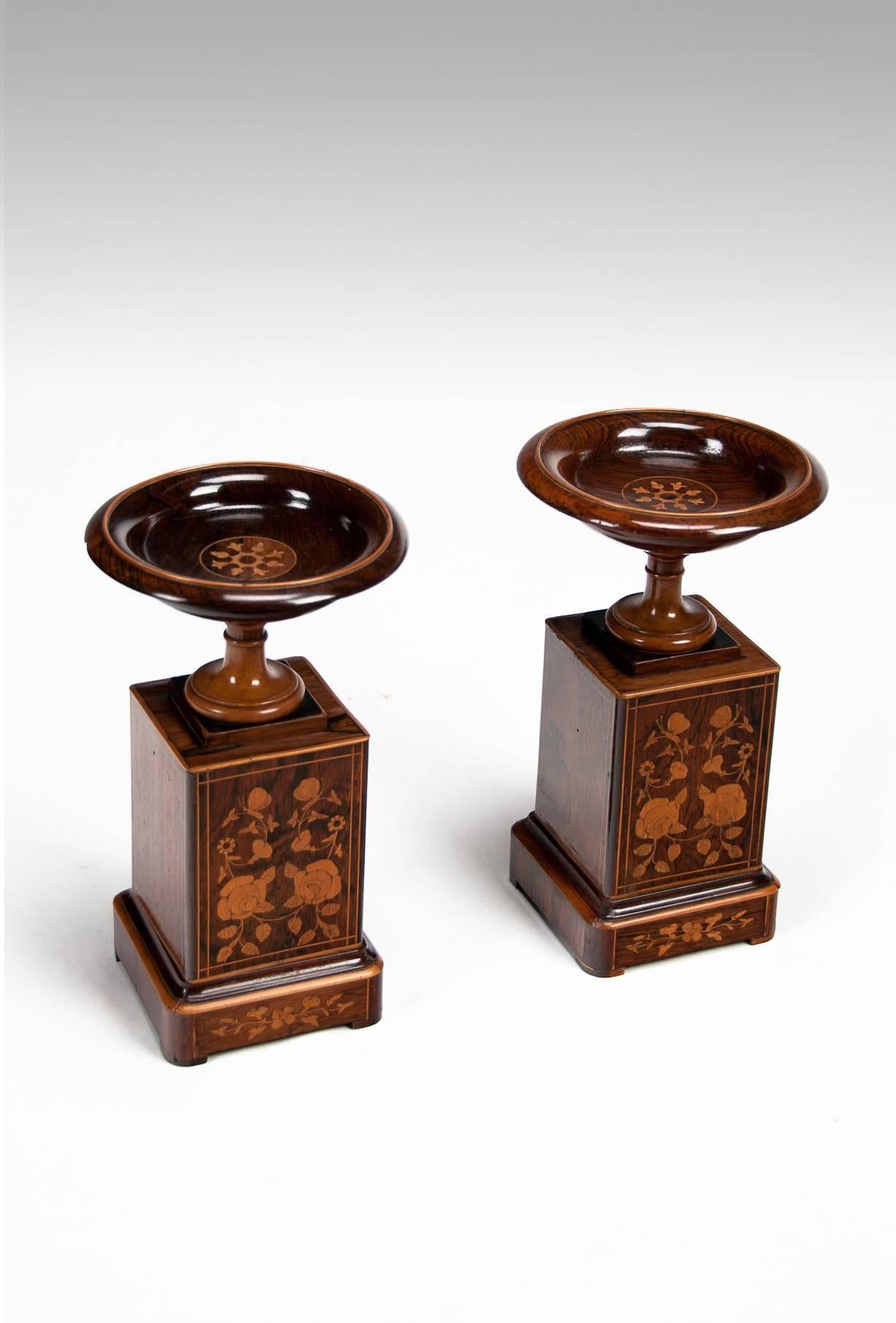 A fine quality pair of 19th Century Rosewood and boxwood Tazzas supported on marquetry inlaid pedestals circa 1860.
The finely dished tops having an inlaid rim with central circular floral pattern support by ring turned boxwood stems above a