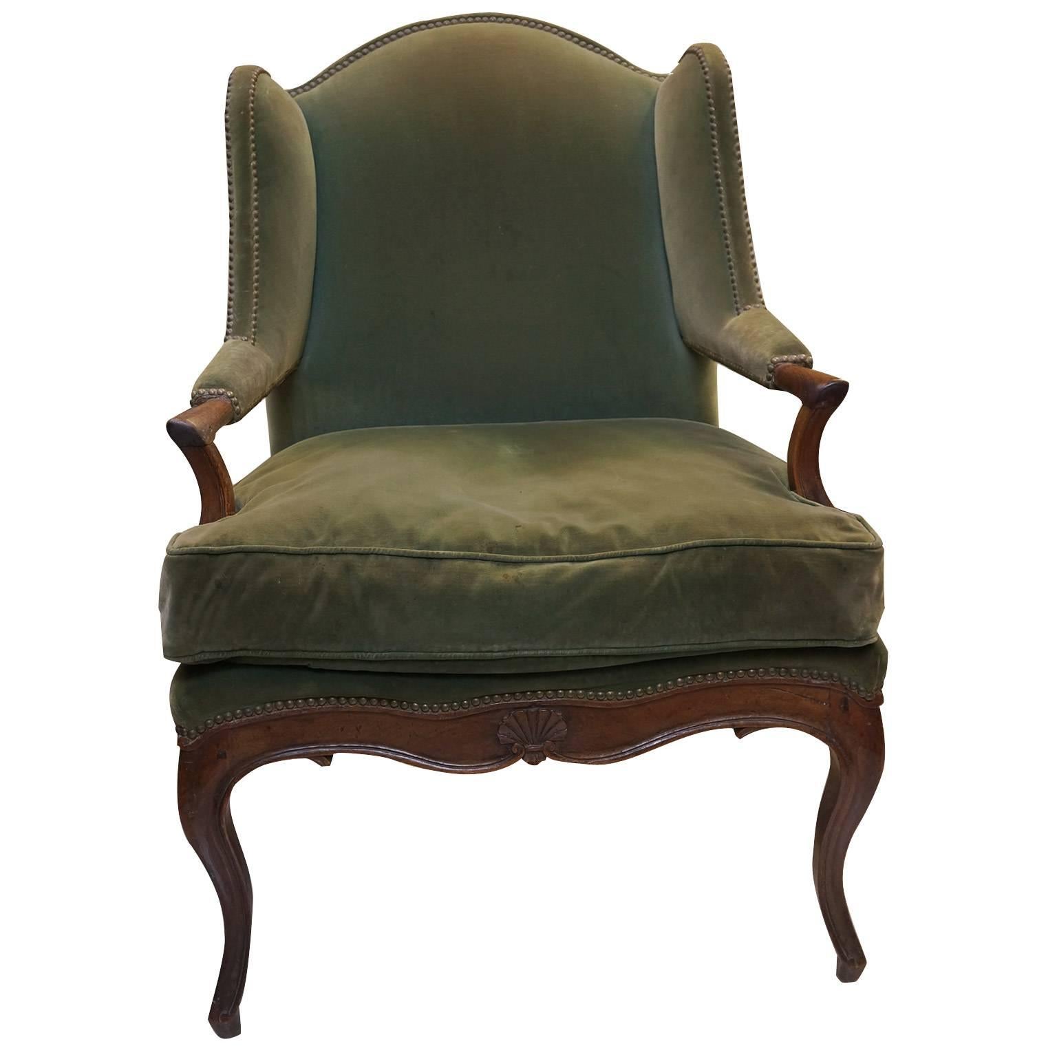 This 18th Century French, walnut chair is nicely carved with a fine patina. A loose down filled cushion and French nail heads are used for the upholstery. Because of the large size, this chair is very comfortable. The walnut frame is in excellent