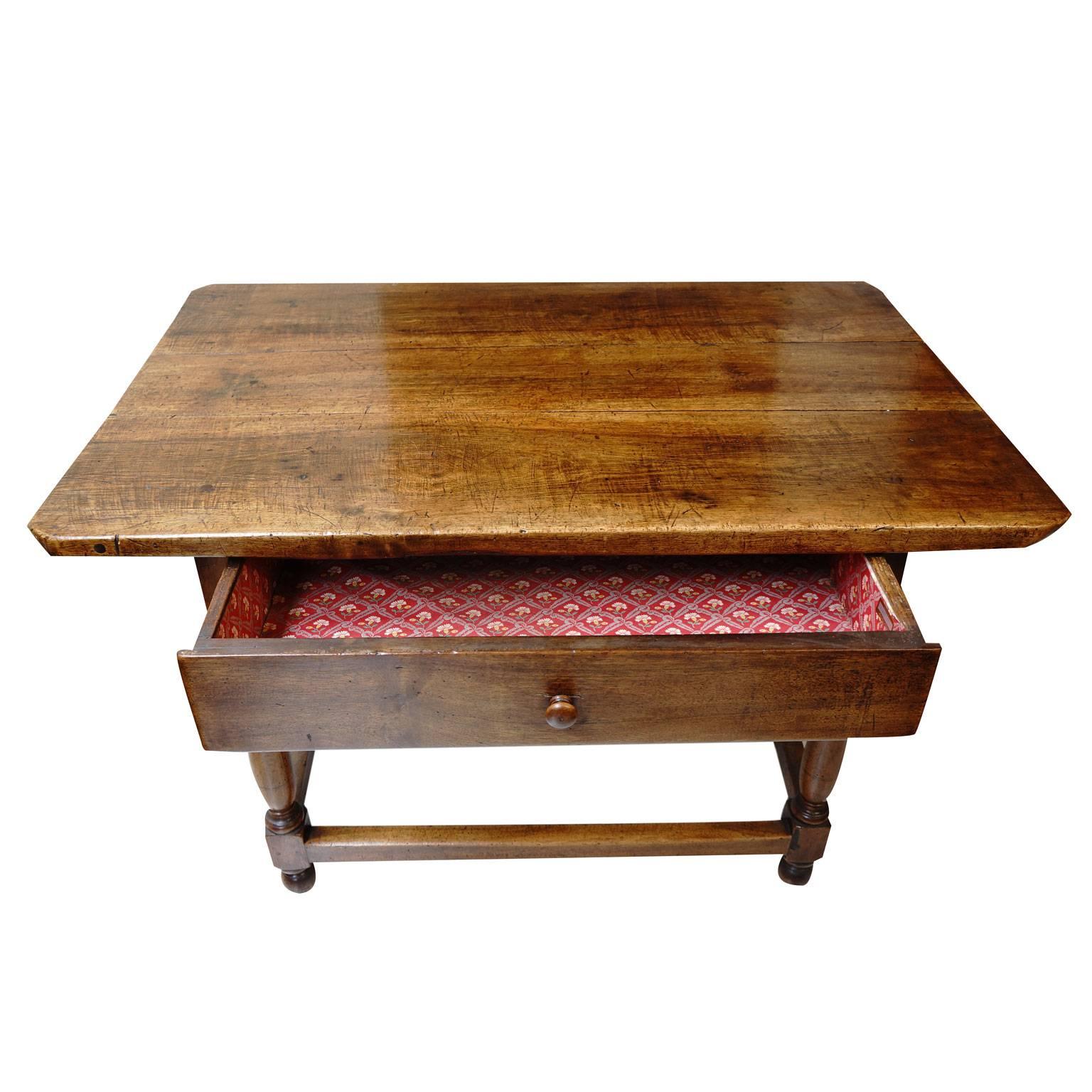 This beautiful 18th Century French walnut table has finely turned legs and a beautiful deep, buttery patina that has developed over age. The table has one large drawer.