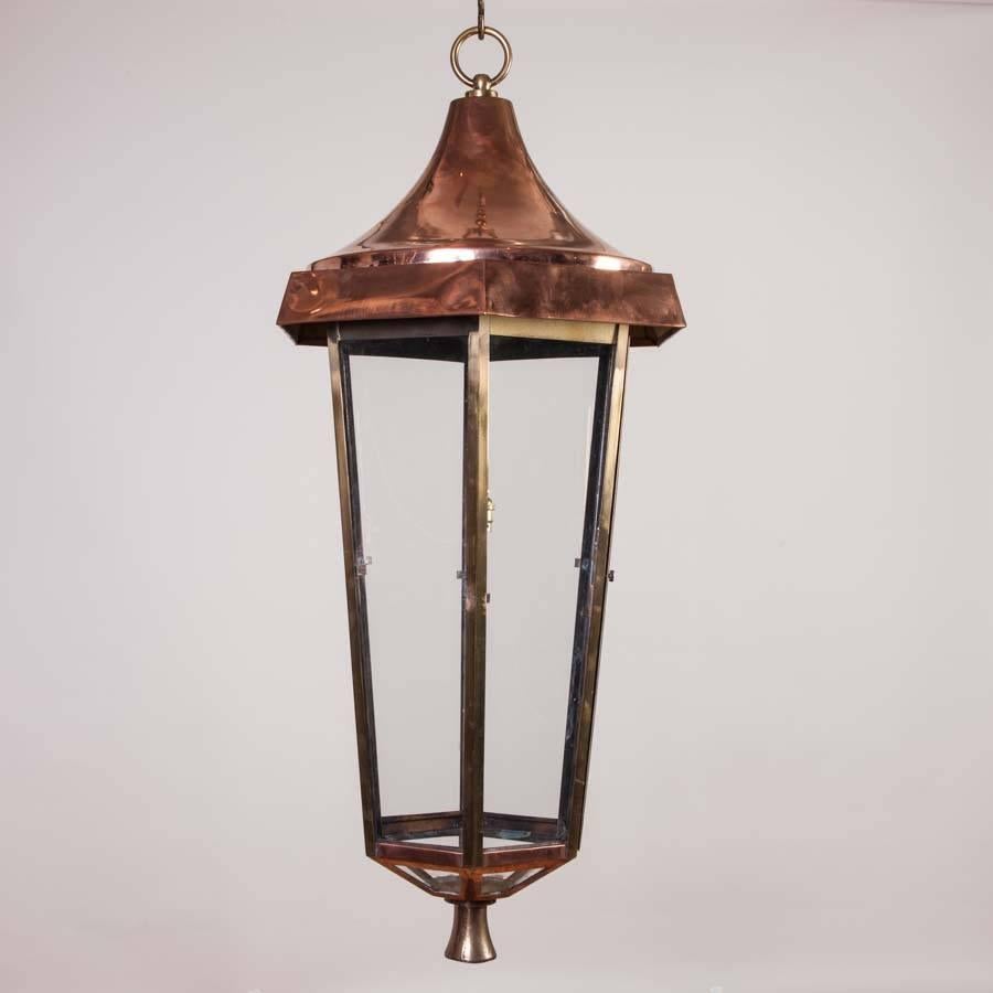 A slender 3 1/2 foot glazed hexagonal copper and brass hall lantern.

With door for access to change the light bulb.

Wired for electricity.