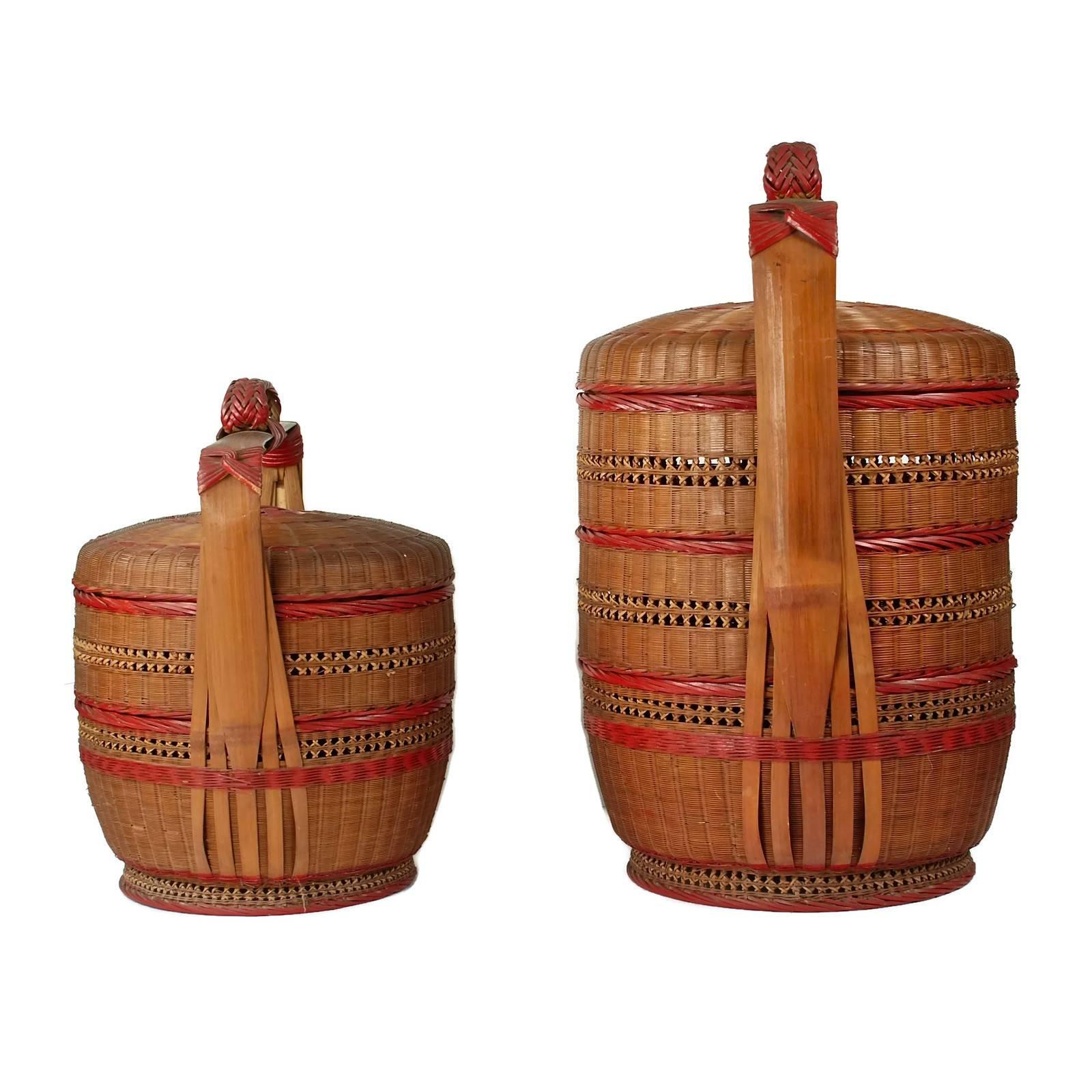 This pair of Japanese wedding baskets date to the early 20th century. The pieces are composed of intricately woven bamboo with the larger having three tiers while the smaller has two. The smaller basket stands 18" tall to the top of the loop