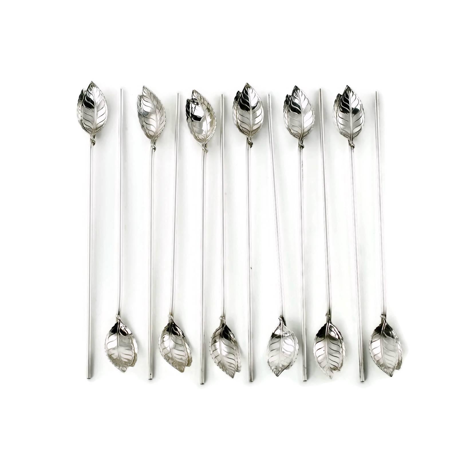 This set of 12 mint julep spoons / straws was made by Tiffany & Company. The pieces are composed of sterling silver with bowls that have been cast in the form of realistic mint leaves with serrated edges. The long thin handles are hollow and also