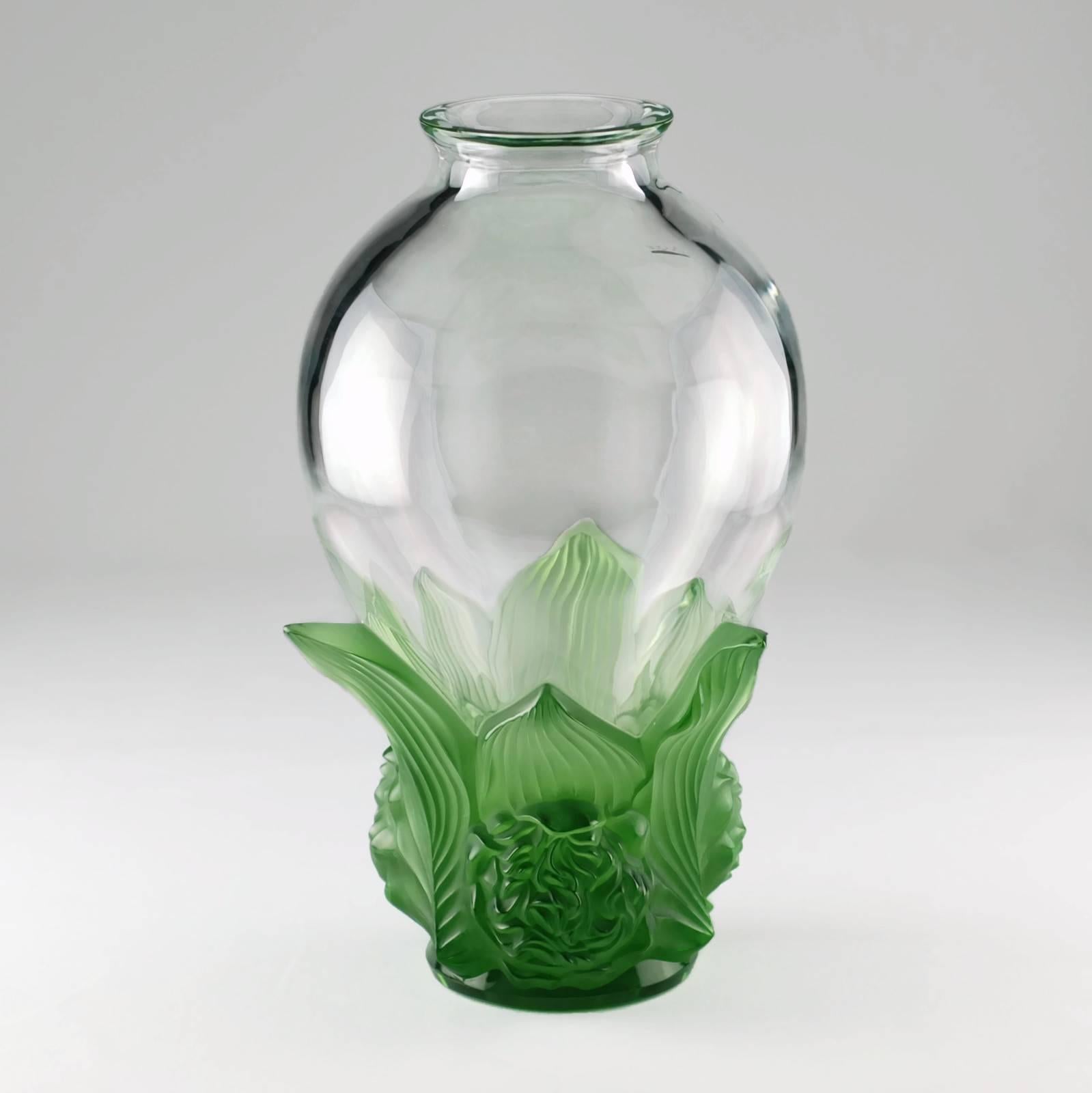 This signed and numbered limited edition Lalique vase is titled vase Pivoines and features a foliate and floral motif at the base which has been executed in jade green satin-finished crystal. The ornate decoration gives way to a clear crystal body
