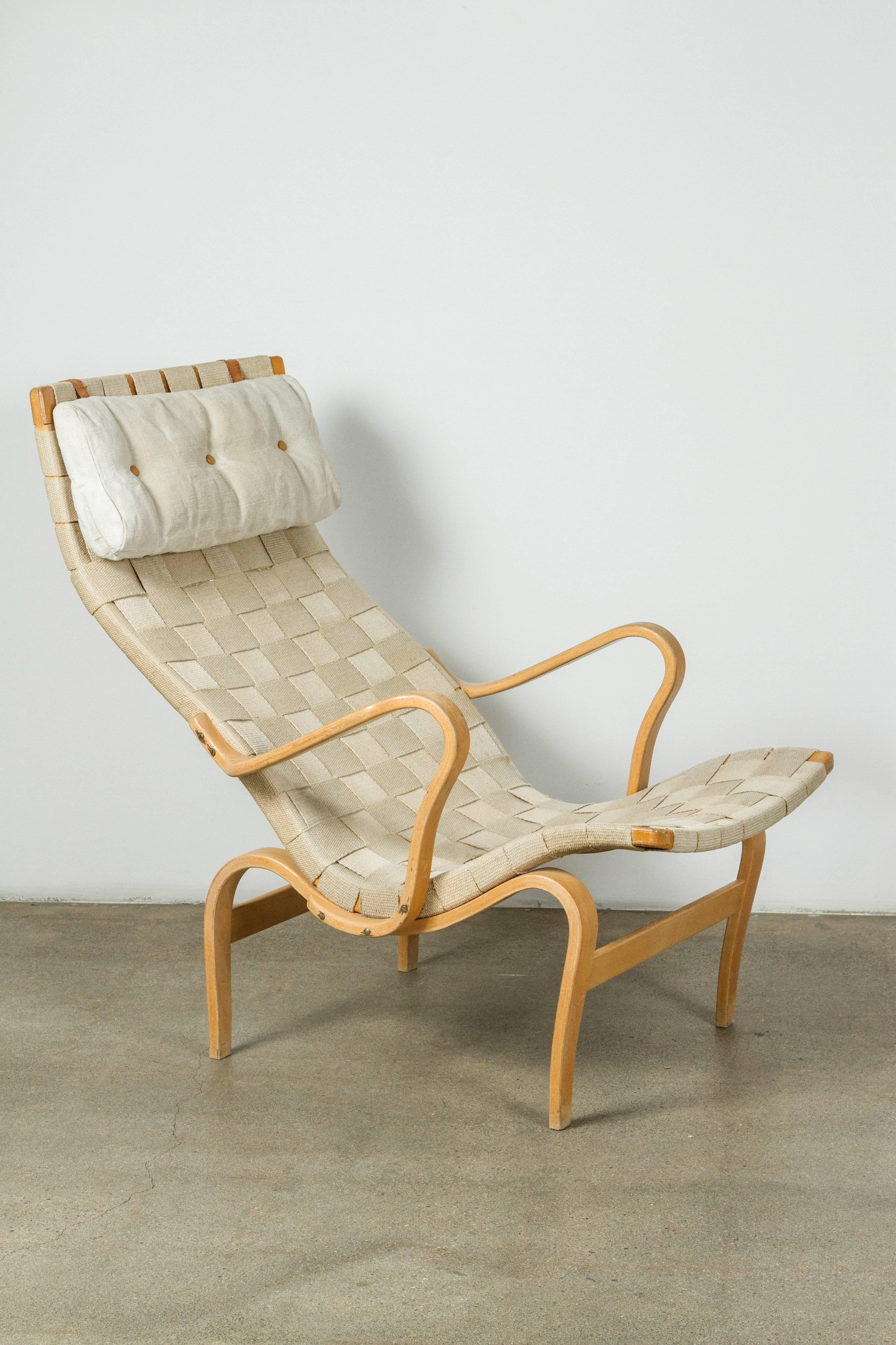Canvas and bent beechwood Pernilla chair with ottoman by Bruno Mathsson for DUX, made in Sweden, circa 1970s.

Ottoman measures: 20.5 W x 26 D x 16 H inches.