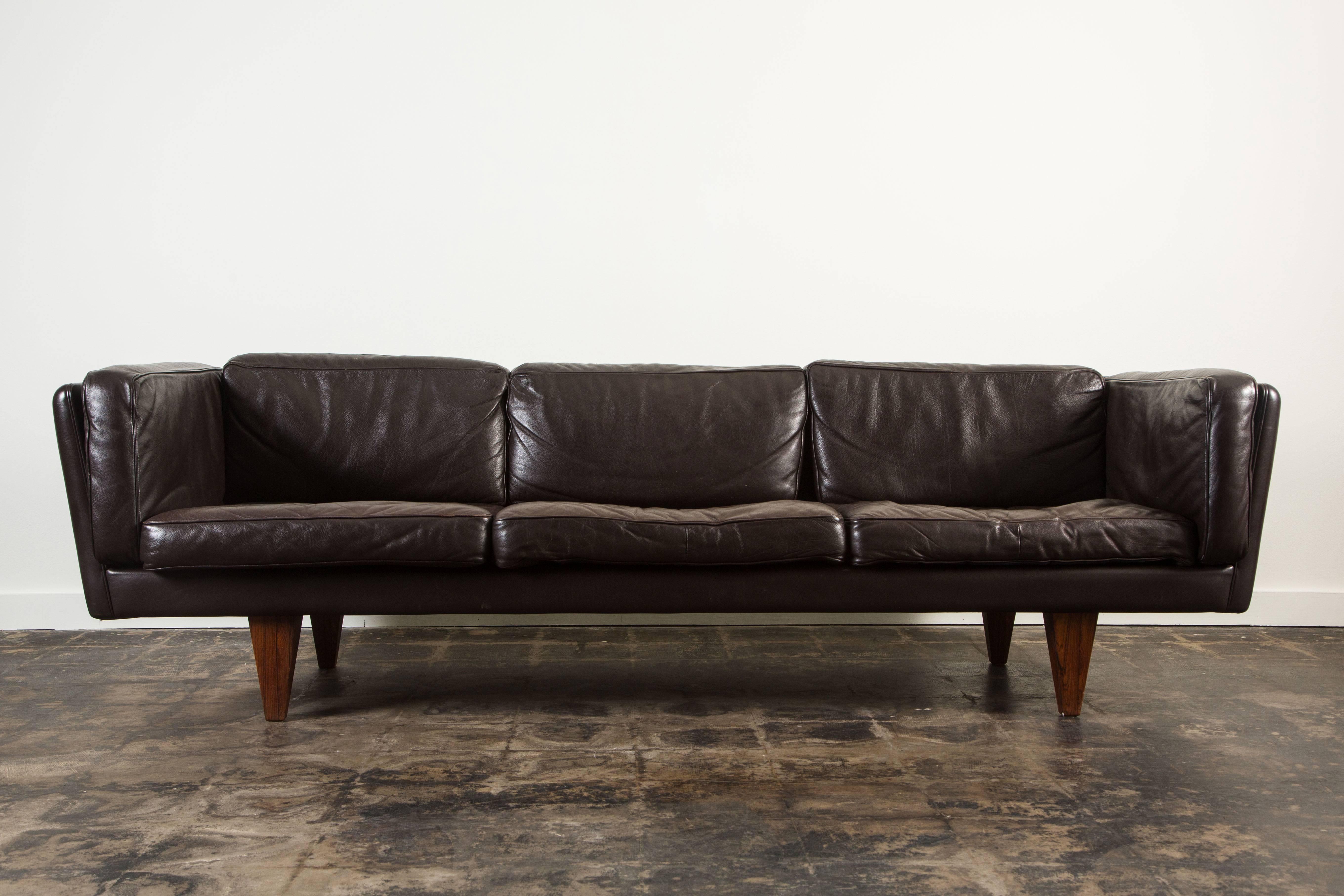 V11 three-seat sofa by Illum Wikkelsø with rosewood legs and original leather upholstery. Made in Denmark, circa 1960s.

 