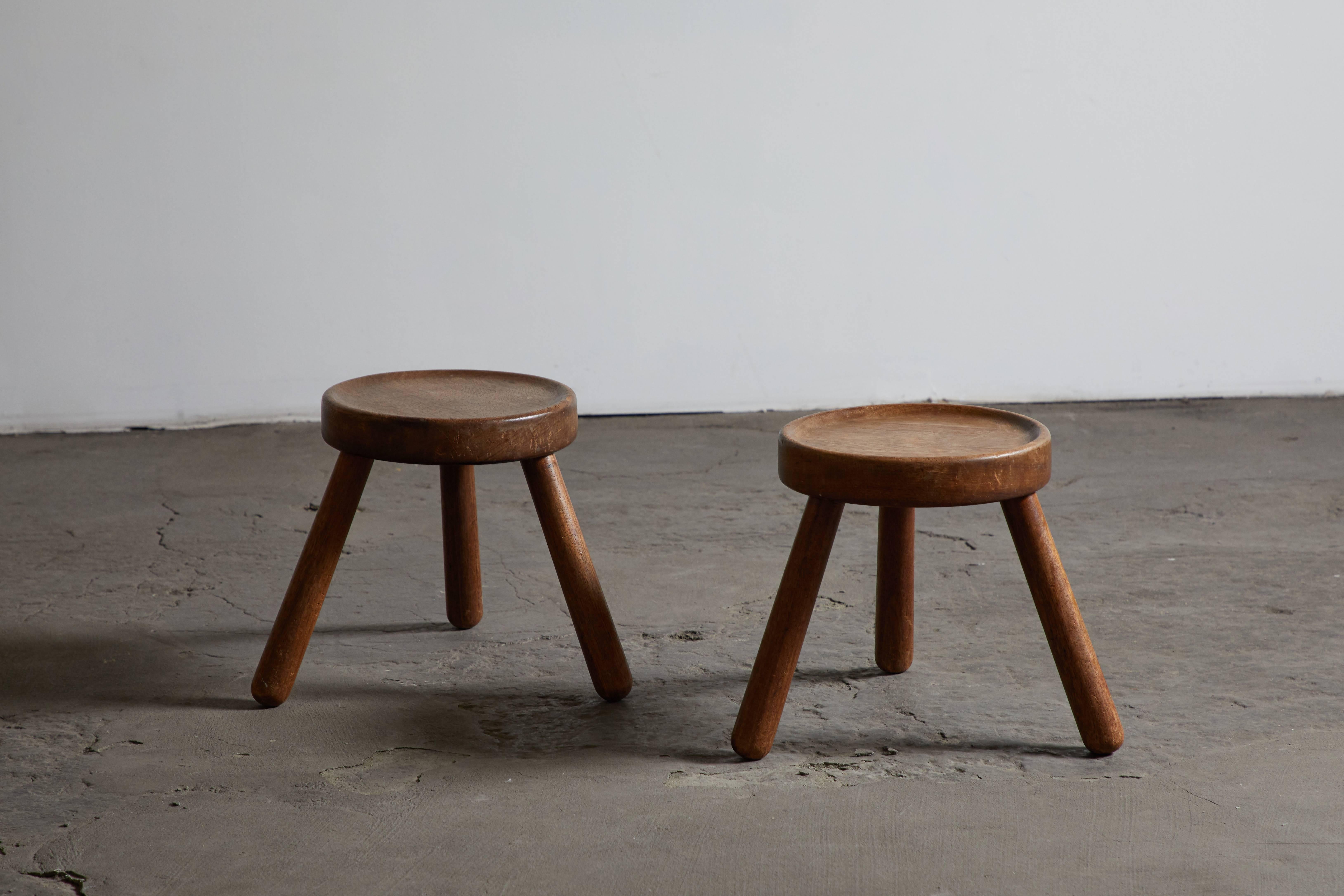 Pair of modernist wood three-legged stools. Made in France, circa 1950s.