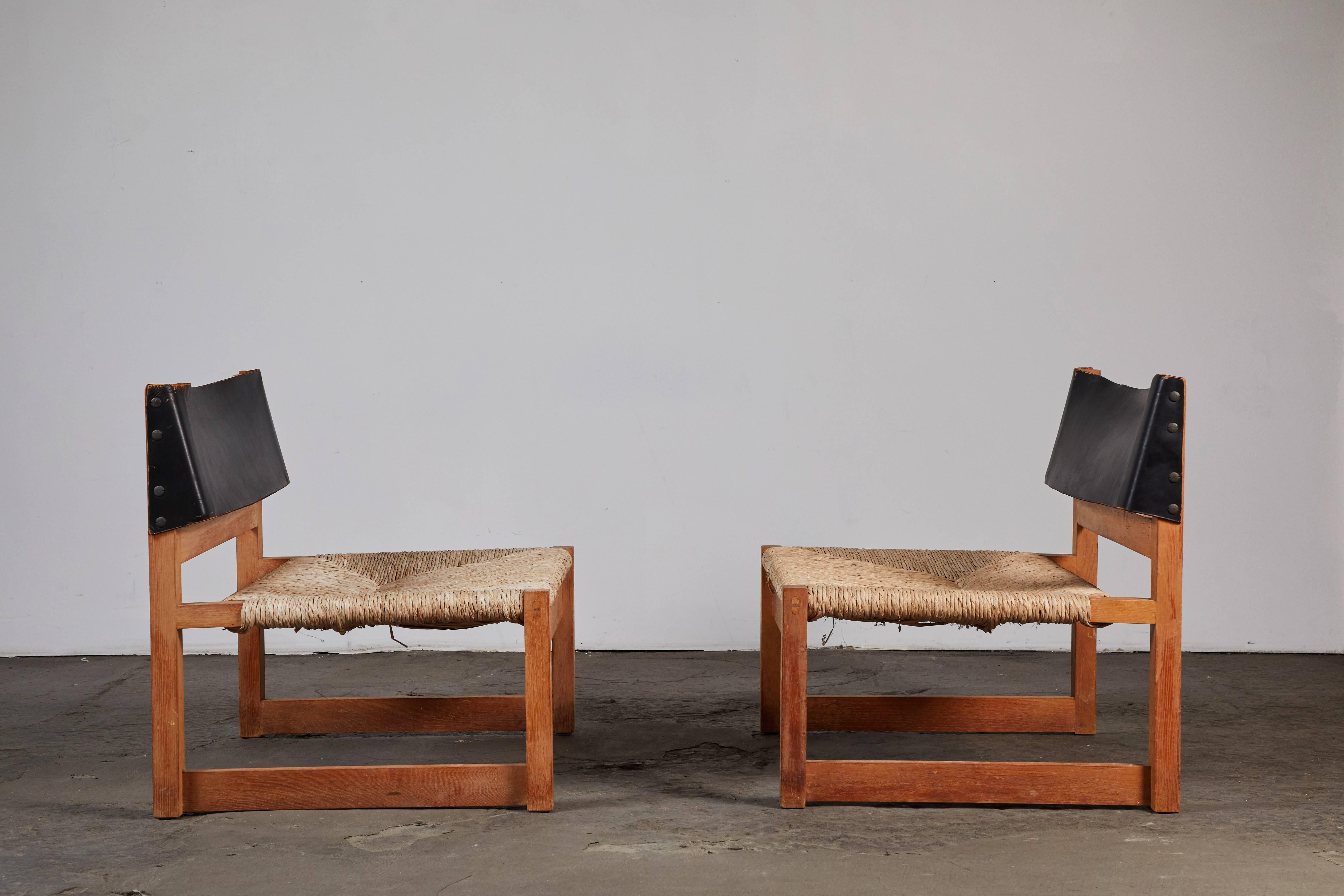 Pair of leather and caned seat wood chairs by Spanish architect, Javier Carvajal for Biosca. Made in Spain, circa 1963. Used in fashion designer, Loewe flagship in Barcelona in 1960s.