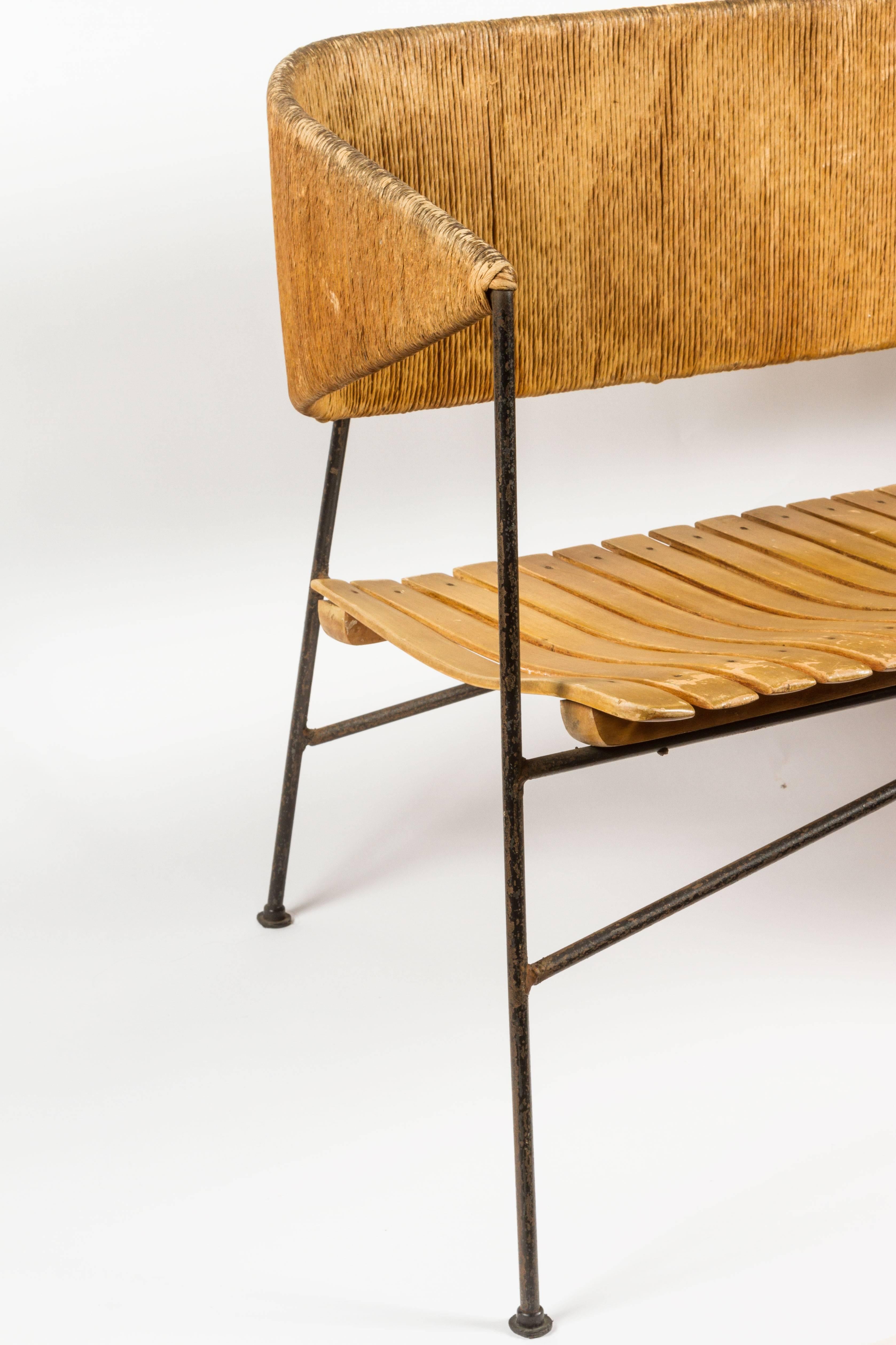 Rare iron, slatted wood and paper cord bench by Arthur Umanoff. Made in USA circa 1960s.
