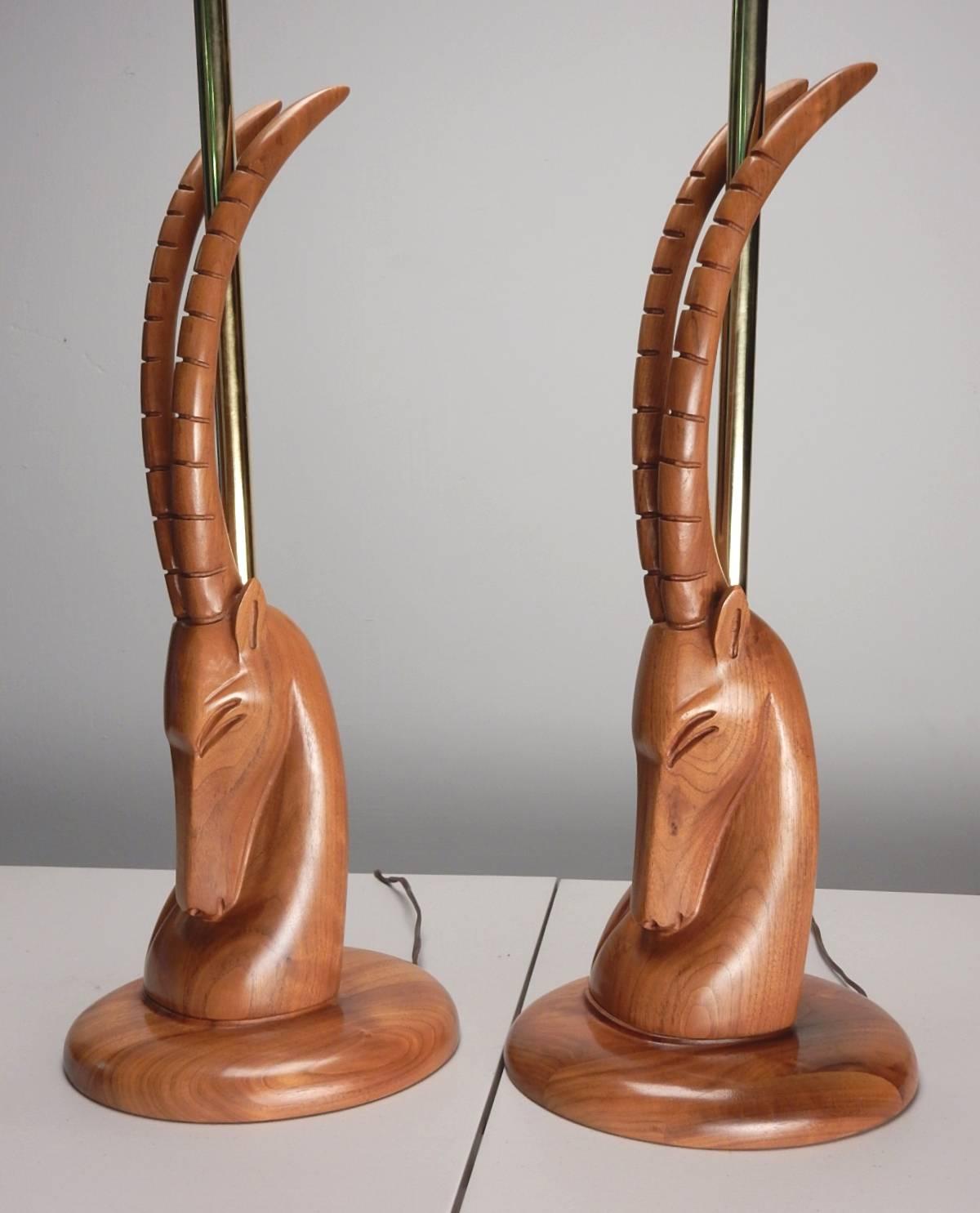 Amazing pair of hand-carved Ibex bust sculpture lamps from the 1940s.
Adroitly carved of exotic hardwood. Includes original shades in a slubby fabric.
Golden brass hardware. Excellent flawless condition.
Measures 41