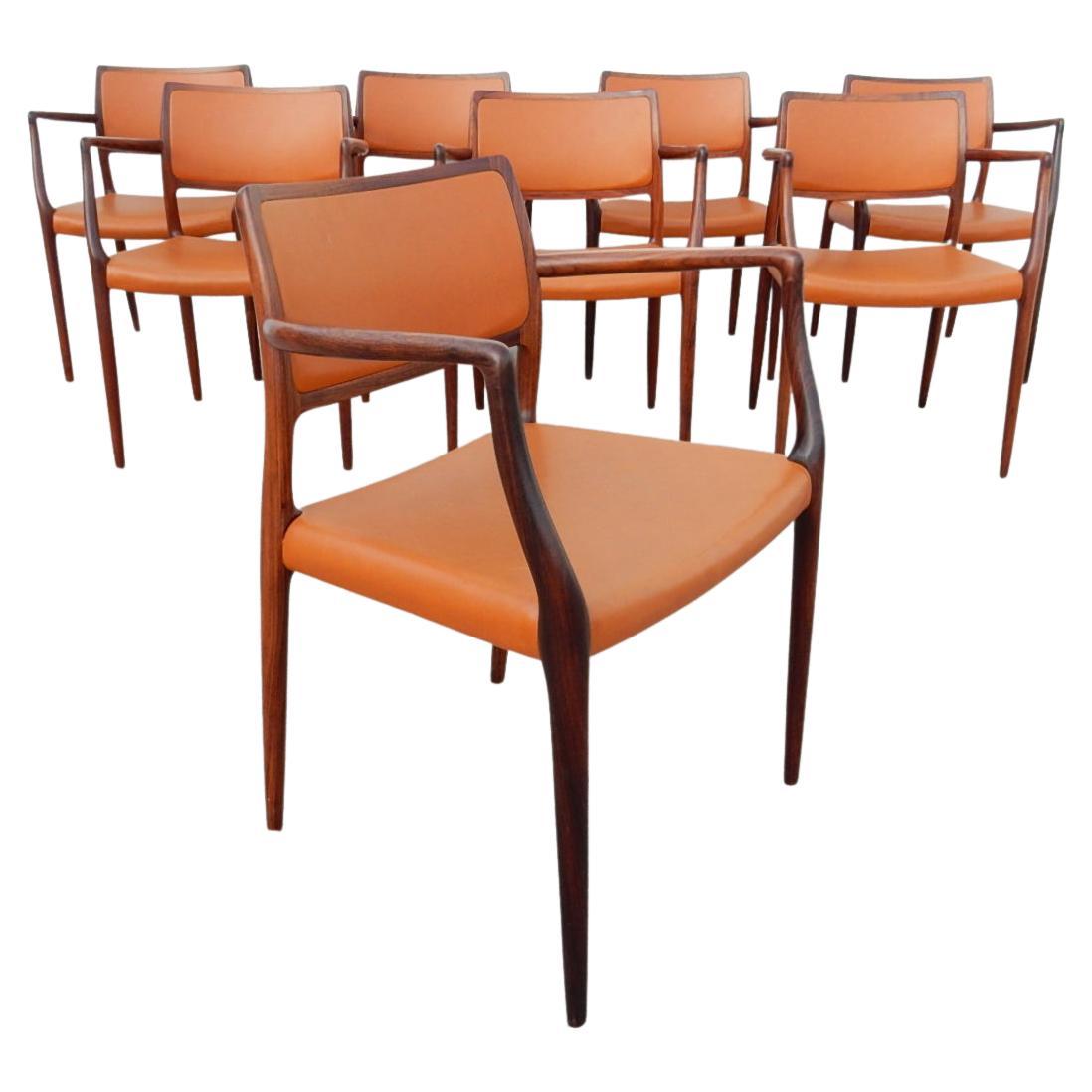 Set of eight exotic rosewood and vinyl armchairs designed by Niels Otto Møller for T.L. Moller of Denmark, chair model #65.
Gorgeous, elegant chairs with sleek lines and amazing wood grain.
All are marked with T.L. Moller brand.

Each chair has been
