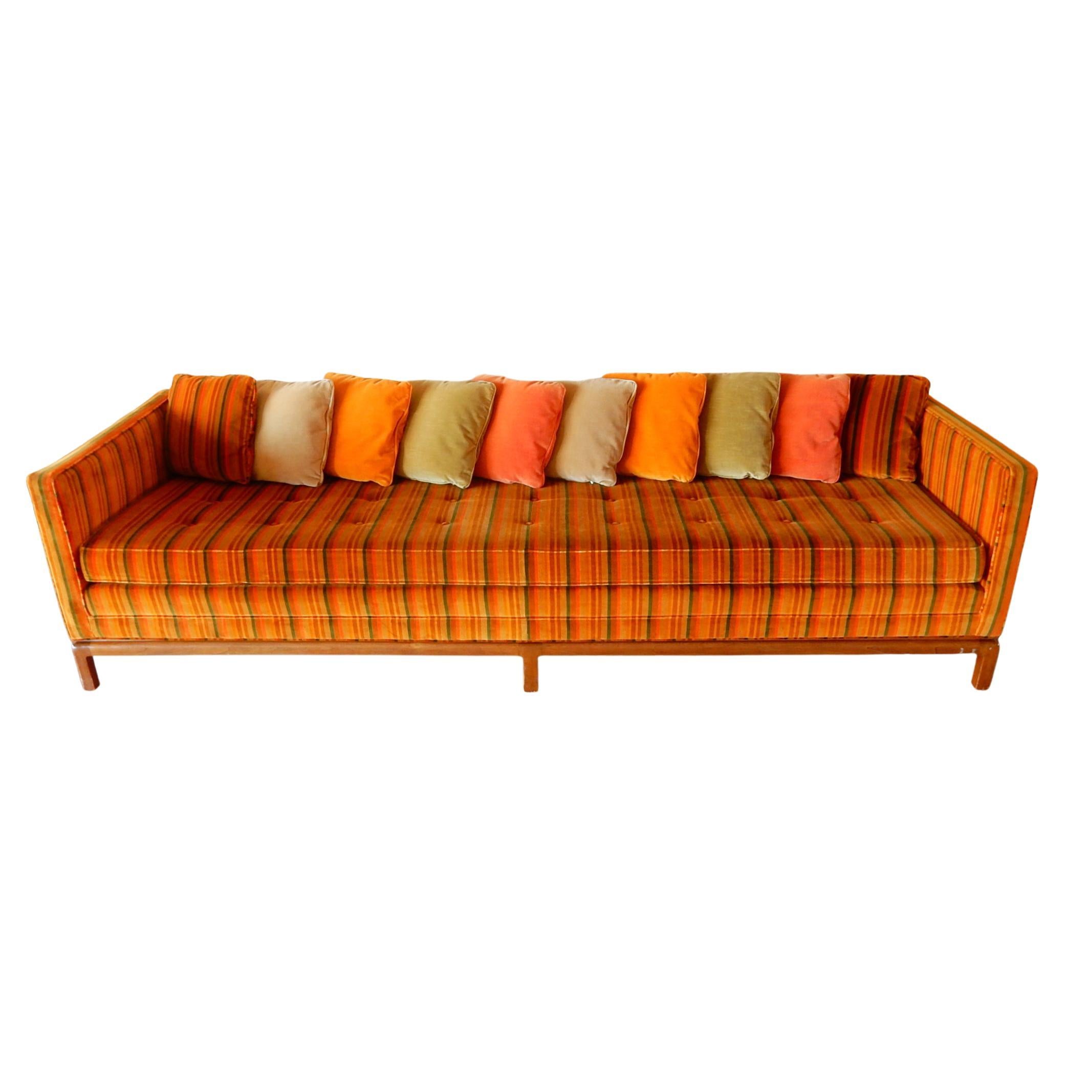 8 foot midcentury sofa by Flair Inc, a division of Bernhardt Furniture of the 1960s and 1970s.
Vivid muted cinnamon red, golden wheat and orange hue Jack Lenor Larsen style velvet upholstery.
Linear design on a 6-leg solid walnut base.
This sofa