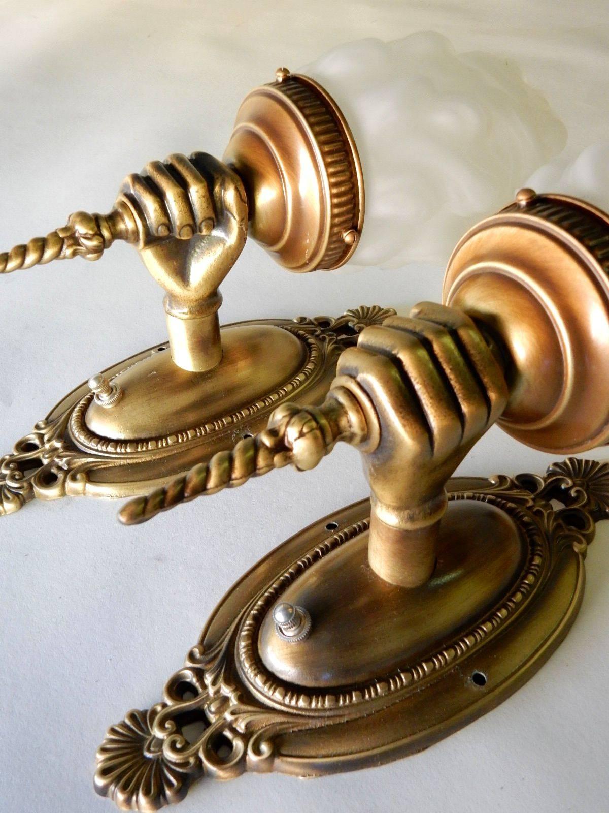 A pair of opposing hand wall sconce lamps circa 1970's.
Brass finish with white glass 