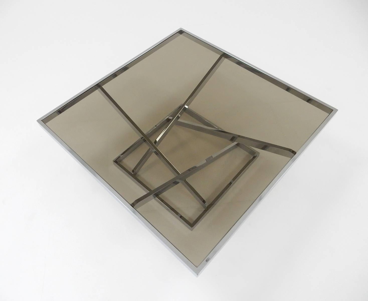 Large architectural design chrome flat bar steel coffee table with smoke glass top by Design Institute of American in the style of Milo Baughman,
circa 1970s. This table is solid and in excellent condition except for a chip in two corners of glass