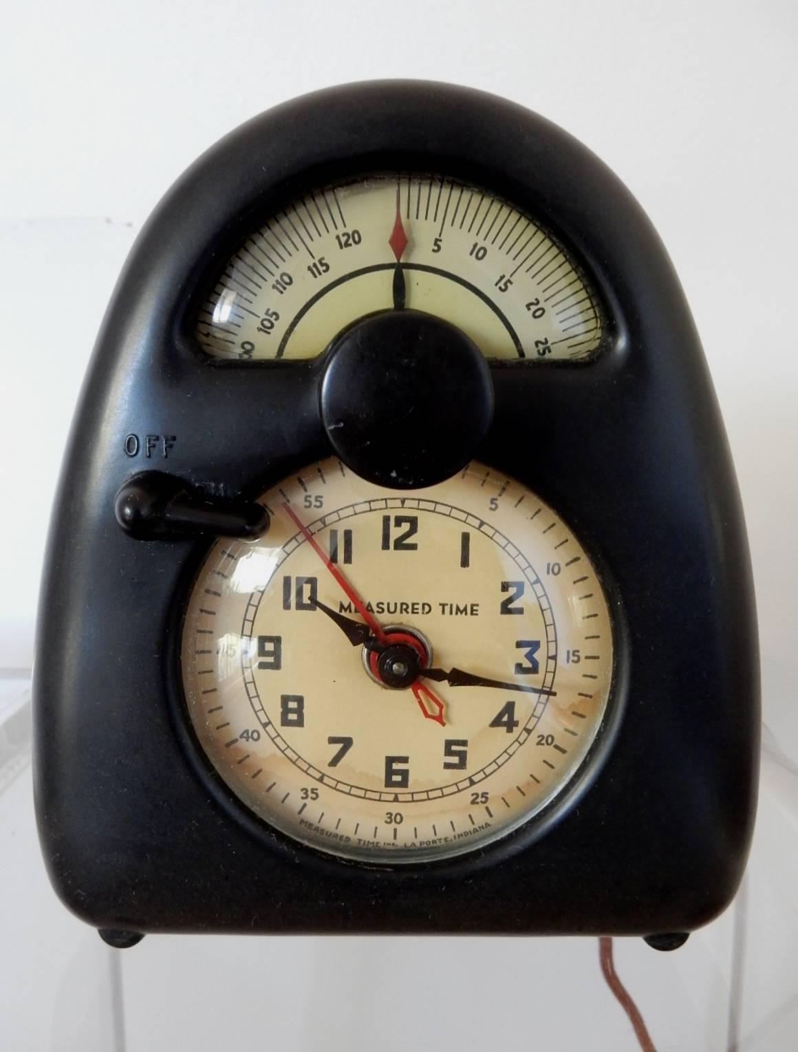 An original design by Isamu Noguchi (1904-1988), circa 1932.
Measured Time, model E, bakelite, enameled metal desk clock.
This clock is completely original including cloth cord and in perfect working order. Keeps perfect time and runs silent. No
