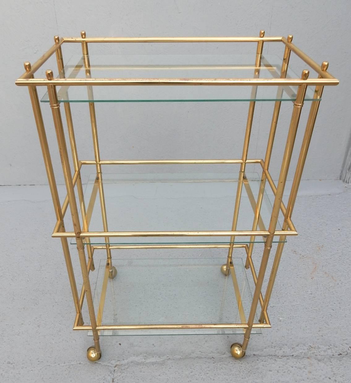 Exceptional tall bar cart with three levels. Angular brass tube design. Very nice quality piece circa 1970s. 
Designer unknown.