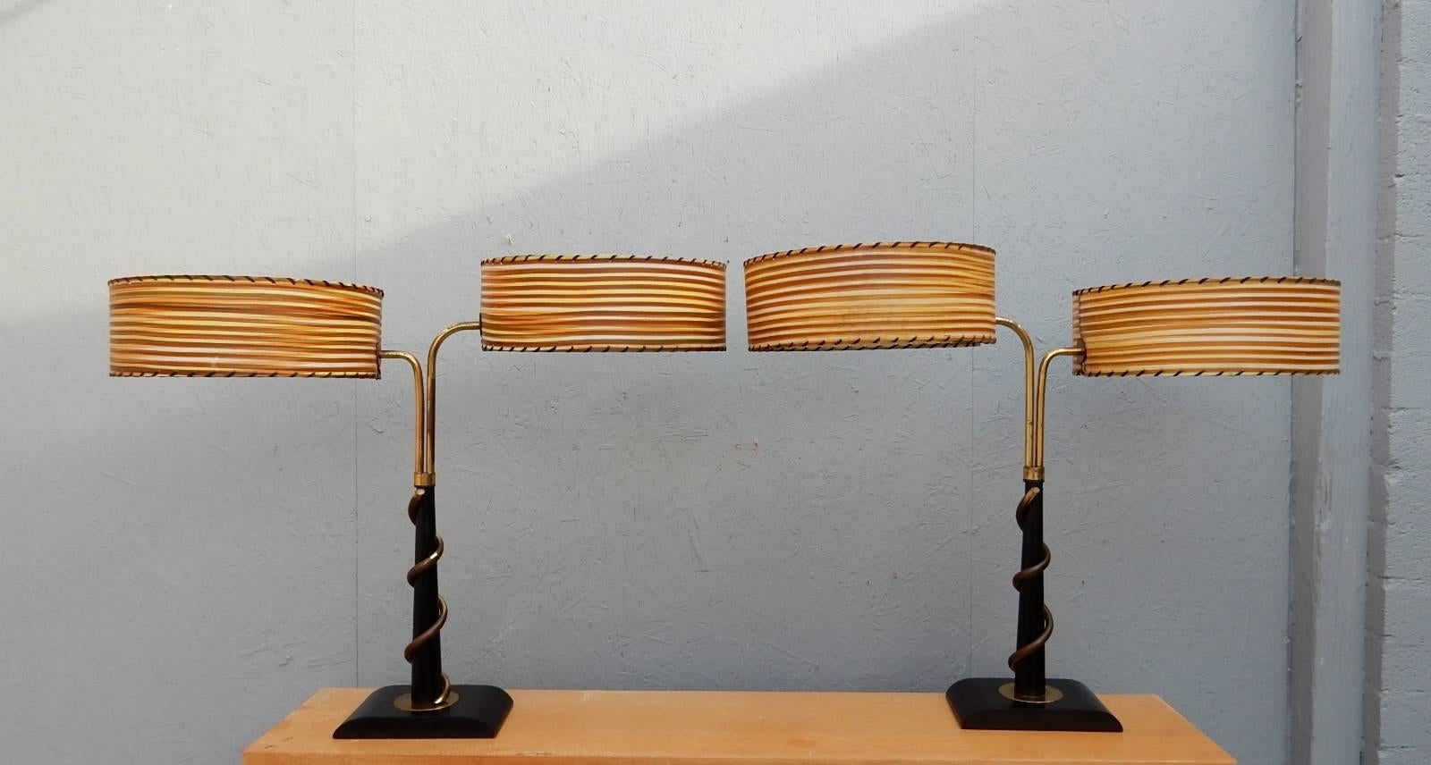 Rare, early pair of lamps from the Majestic Lamp Co.
Brass-plated copper swirl over ebonized oak. Each has two original striped shades. Some fading on shades and tarnish on plating that one would expect from age.