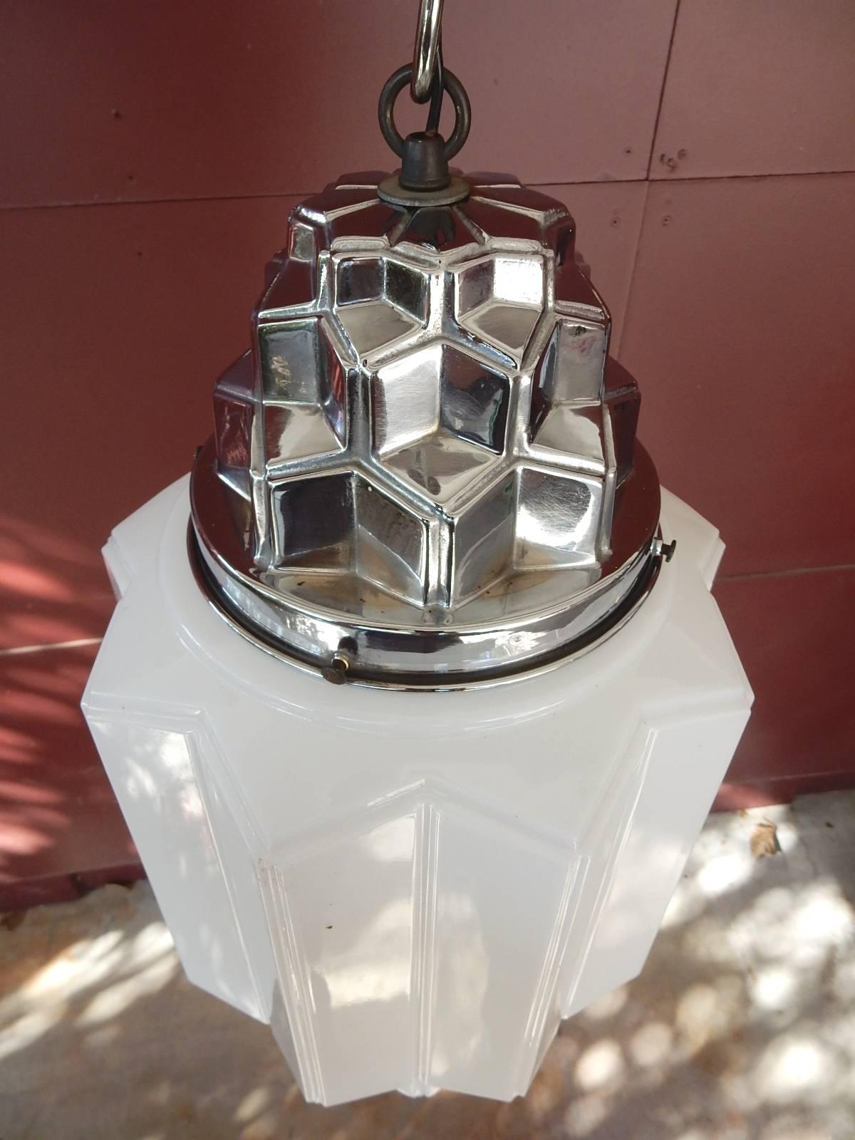 1930's commercial theatre pendant made of thin hand formed milk glass with nickel-plated cap that identically mimics the cubist design of globe. Takes a single standard light bulb. New chrome chain, wiring and ceiling cap giving it a 39