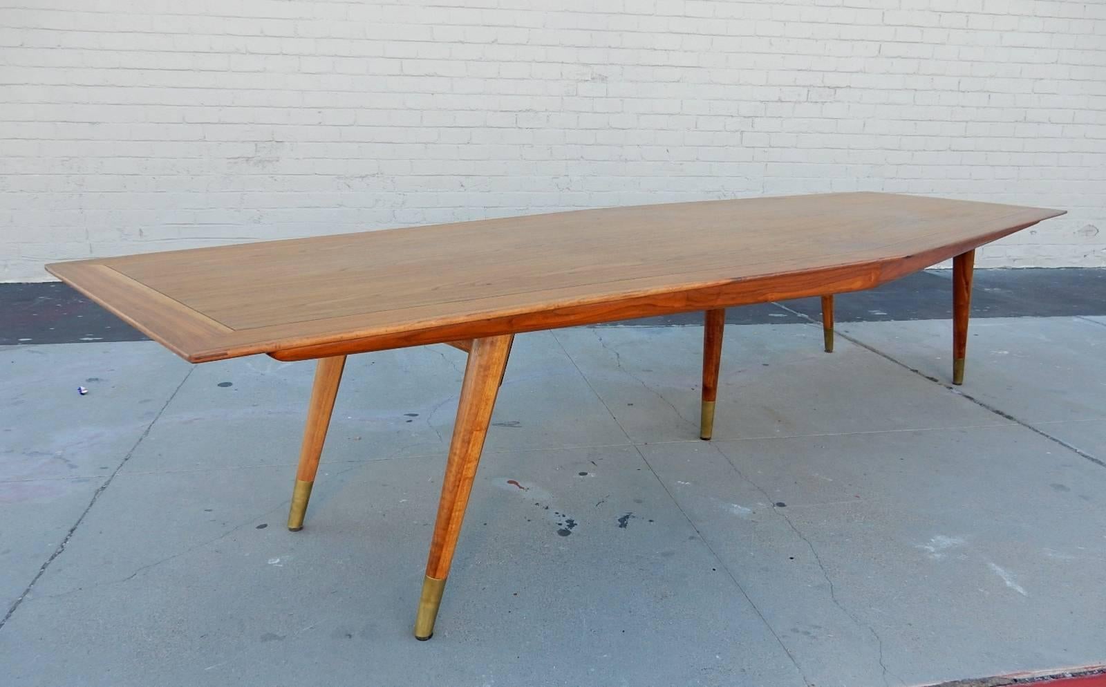 Enormous conference room table by Stow-Davis furniture. Designed by Giacomo Buzzitta, circa 1958.
Diamond shape walnut top and splay legs capped with brass feet.
Measures 12 feet long X 4.5 feet wide X 29