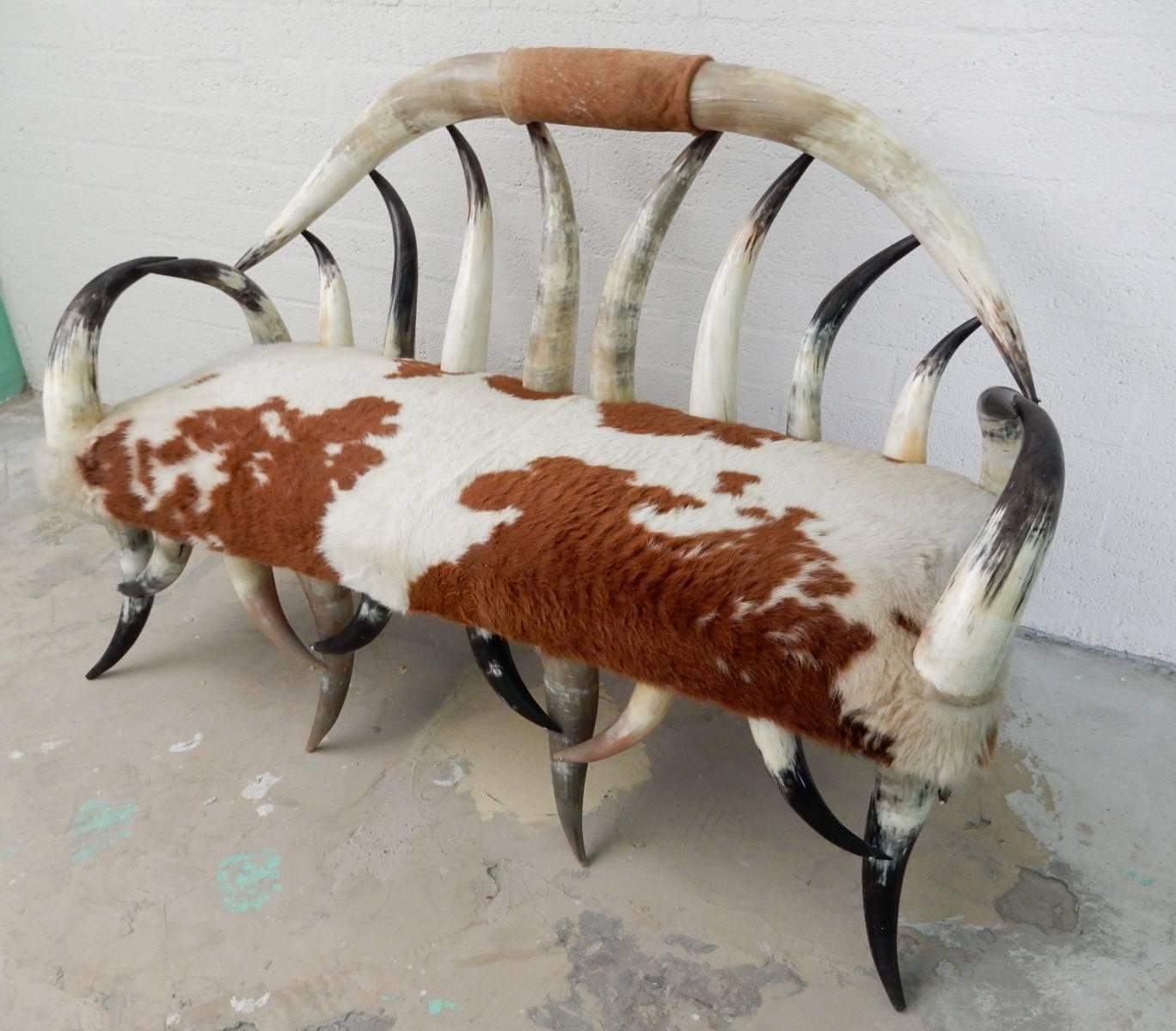 Fabulous cowhide upholstered longhorn steer horn settee in excellent original condition.
Solid, super comfortable and perfect for the eclectic home.
 