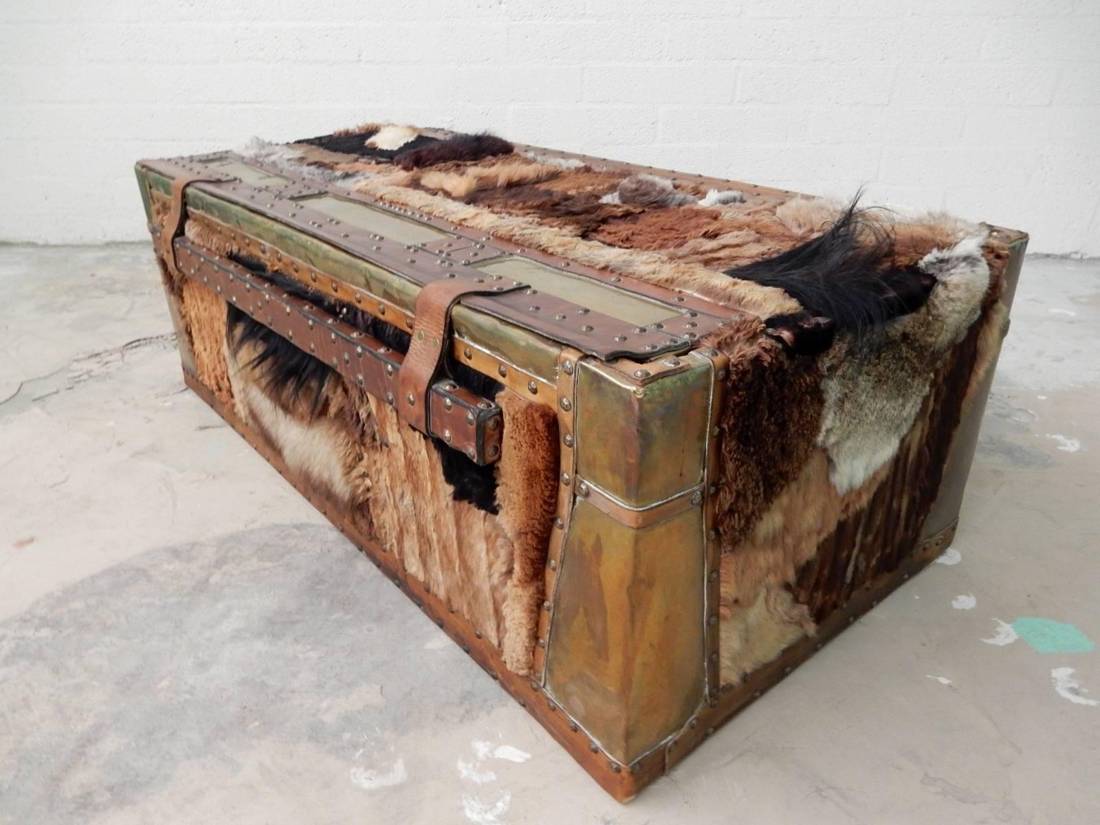 Unique one-of-a-kind vintage brass and leather trunk covered in exotic fur pelts from around the world with a huge leather handle. Brass upholstery tacks and leather strapping surround fur. Signed ~W.W.Daniel, Aug. '74~ on bottom.
This would make a