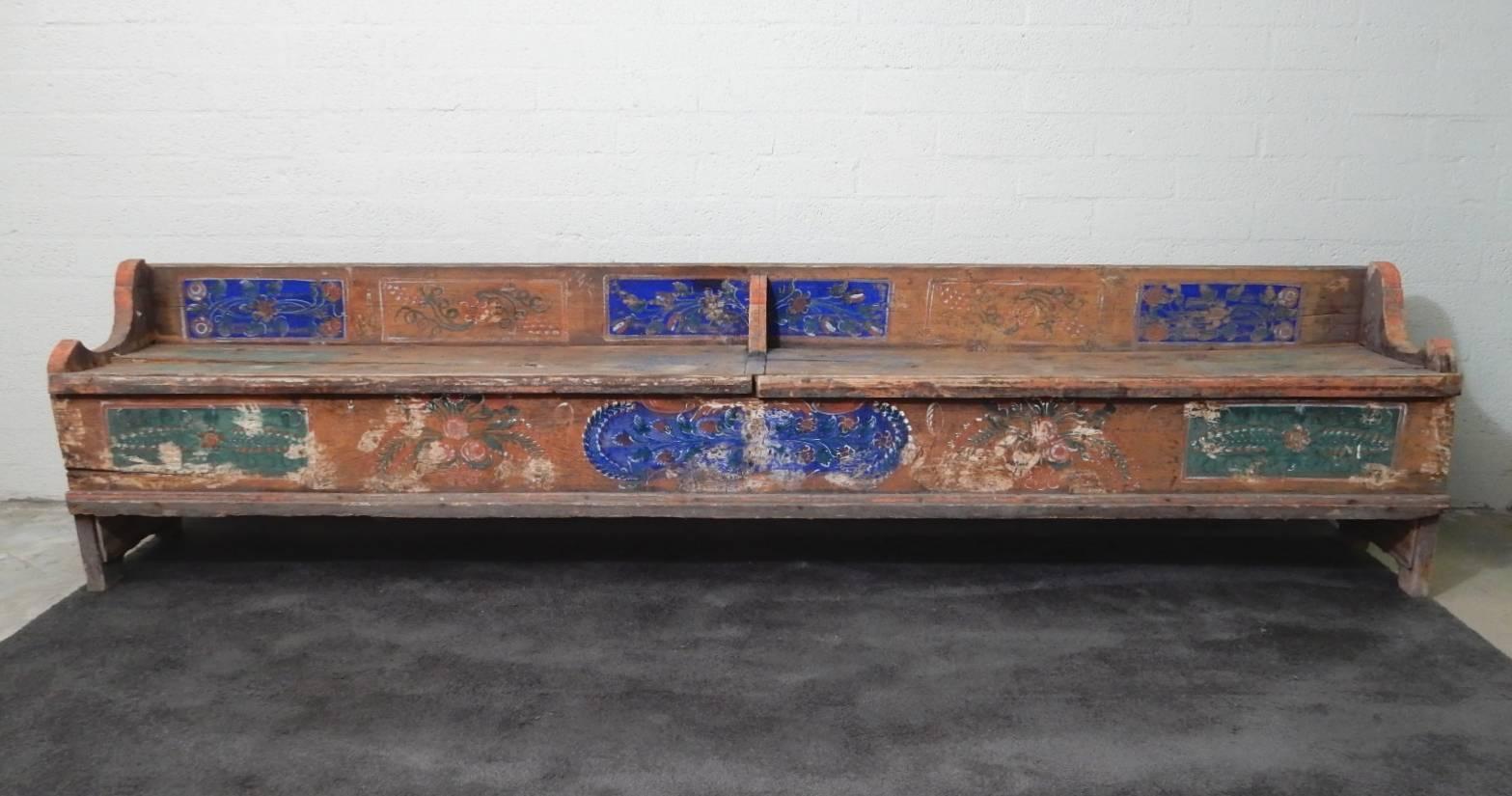 Antique storage bench from Sweden with original floral painting.
A rustic and primitive work of art.
Both seat planks lift up to expose open storage.
It is all original with hand-forged nails. Measures 10 feet long.