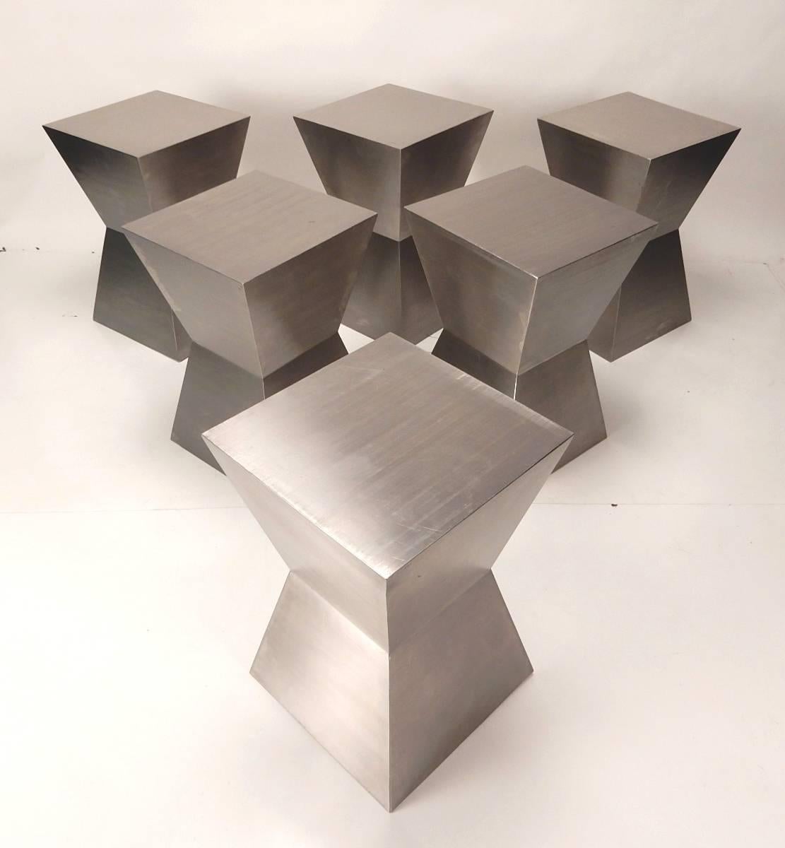 This set of six seamless, brushed stainless steel sculpture stools or tables, would make an amazing lounge area complete.

They nest together neatly like a puzzle or you can spread them around.
Faceted sides reflect light around the room. 
Heavy