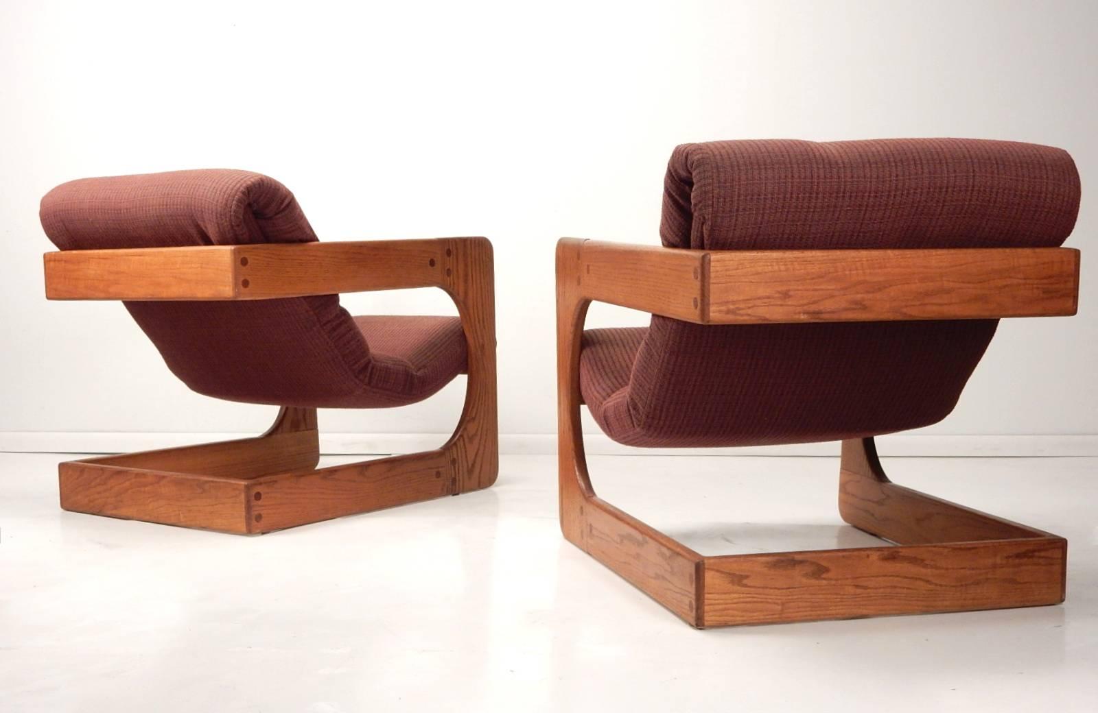 Completely original cantilever lounge chairs designed by Lou Hodges, circa 1970s.
Solid oak construction with sling seating upholstered in a blended weave.
Neutral colors blend well in any decor.
     