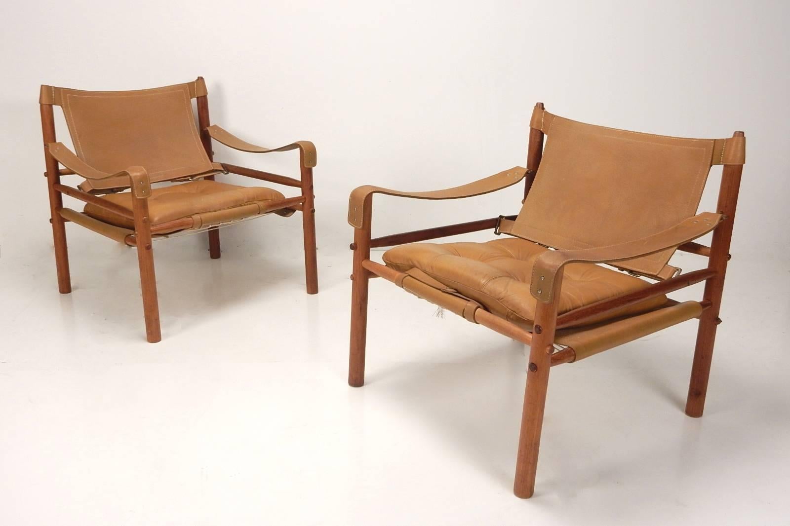 Matched pair of gorgeous Brazilian rosewood safari lounge chairs mounted with supple caramel leather straps and cushions.
Designed by Arne Norell for Scanform of Columbia.