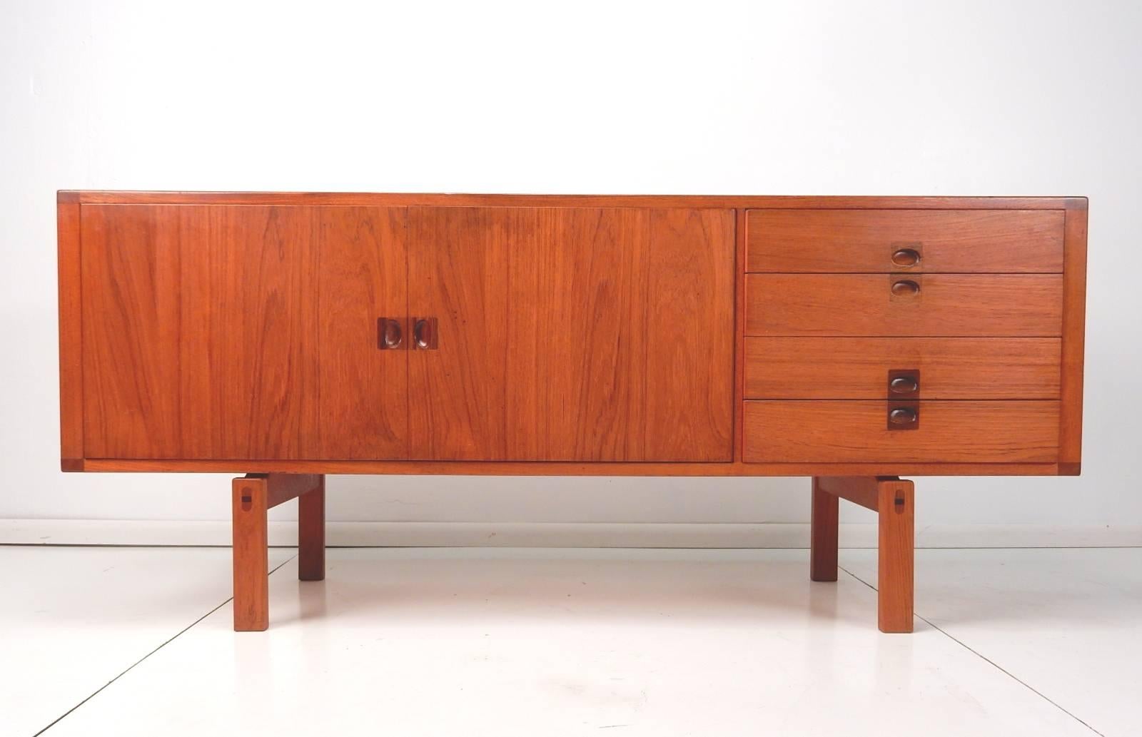 1950s Lennart Bender for Ulferts of Sweden sideboard cabinet from the 'Corona' line.
Teak with rosewood inlay pulls. Beautiful finished back with stupendous grain.
Four drawers with the top being felt lined and a separate mini flatware