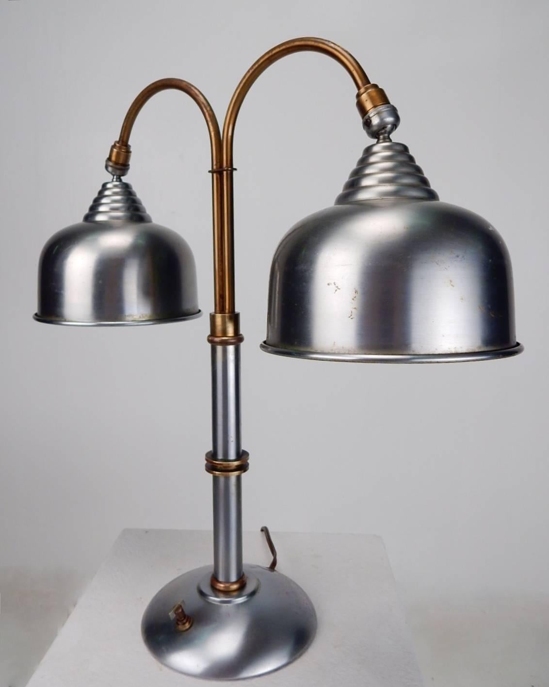 1930s Faries Lamp CO. Desk lamp.
Double shade swivel heads. Two-tone brass/brushed steel body.
Each shade takes a standard 60 watt bulb.
It is in perfect working order with it's original three-way propeller switch.
Marked Faries Decatur, ILL