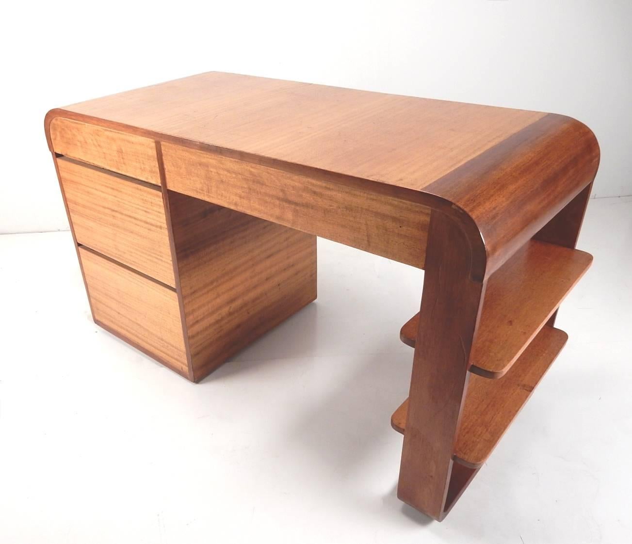 Phenomenal, 1930s streamline two-tone mahogany desk.
Masterfully crafted with finished back with hidden pulls making both front and back look identical.
Designer unknown.
Solid original condition, not refinished with warm aged patina.