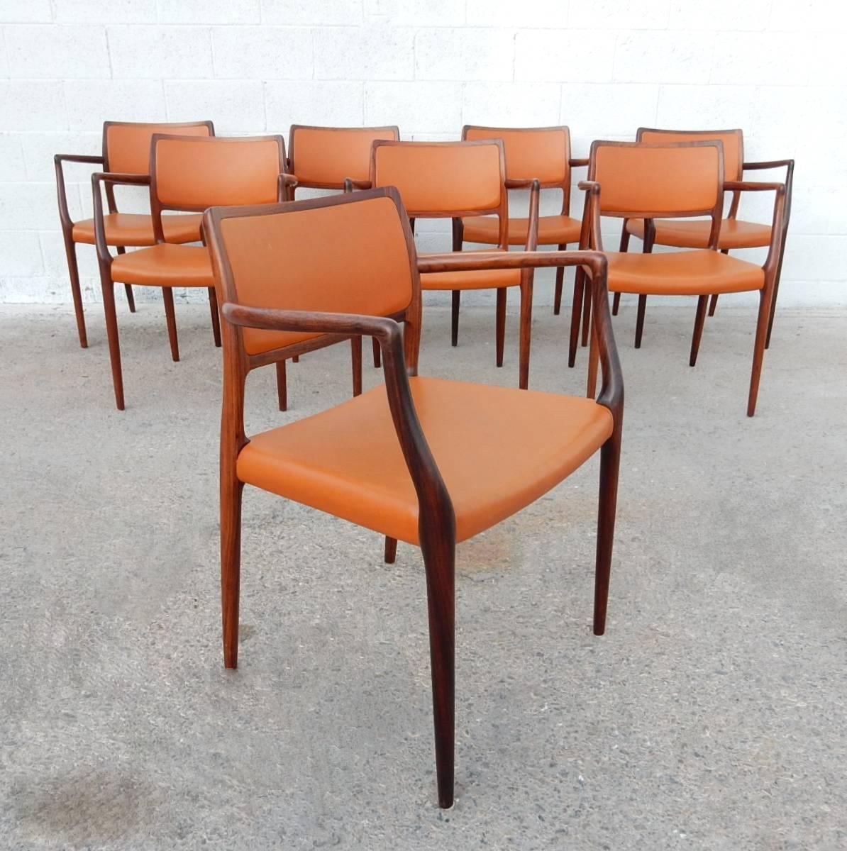 Set of eight exotic wood and leather arm chairs designed by Niels Otto Møller for T.L. Moller of Denmark, chair model #65.
Gorgeous, elegant chairs with sleek lines and amazing wood grain.
All are marked with T.L. Moller brand.

Each chair has been