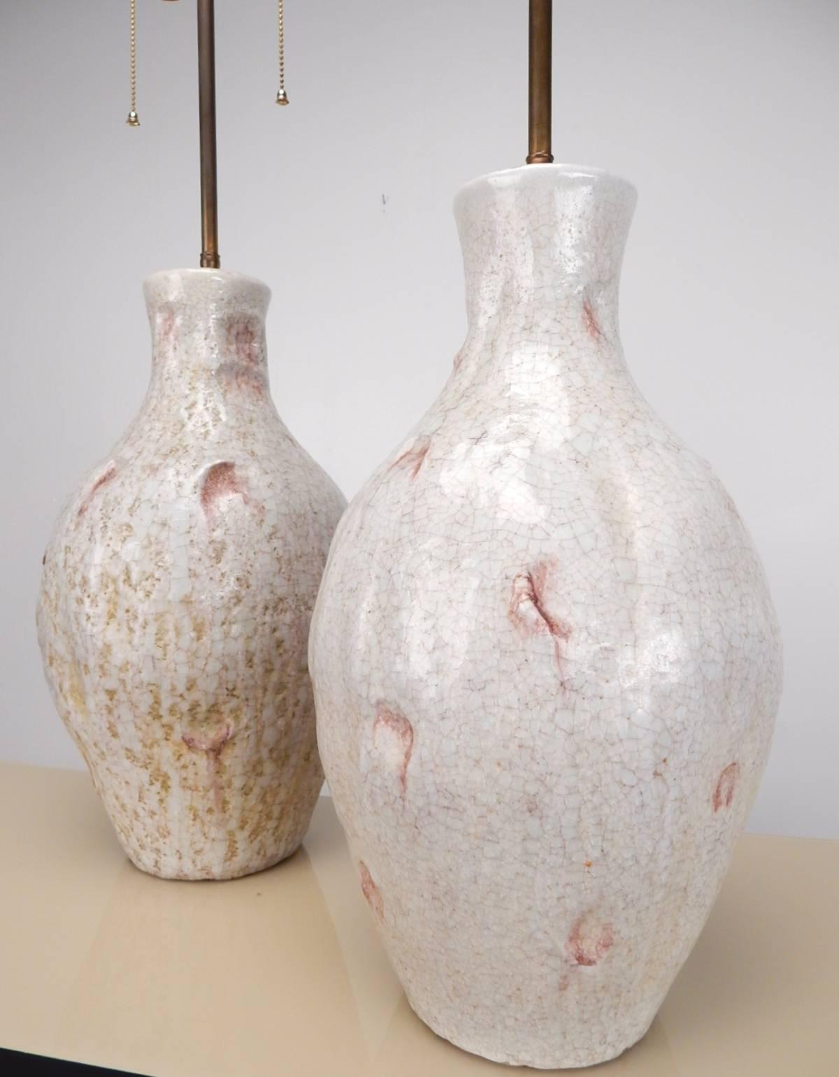 Signed pair of Marcello Fantoni art pottery table lamps with amazing glaze.
White with abstract thumb dimples dripping with light violet glaze.
Glaze crazing over entire body. Really stunning midcentury design pieces.
Each is signed by Fantoni