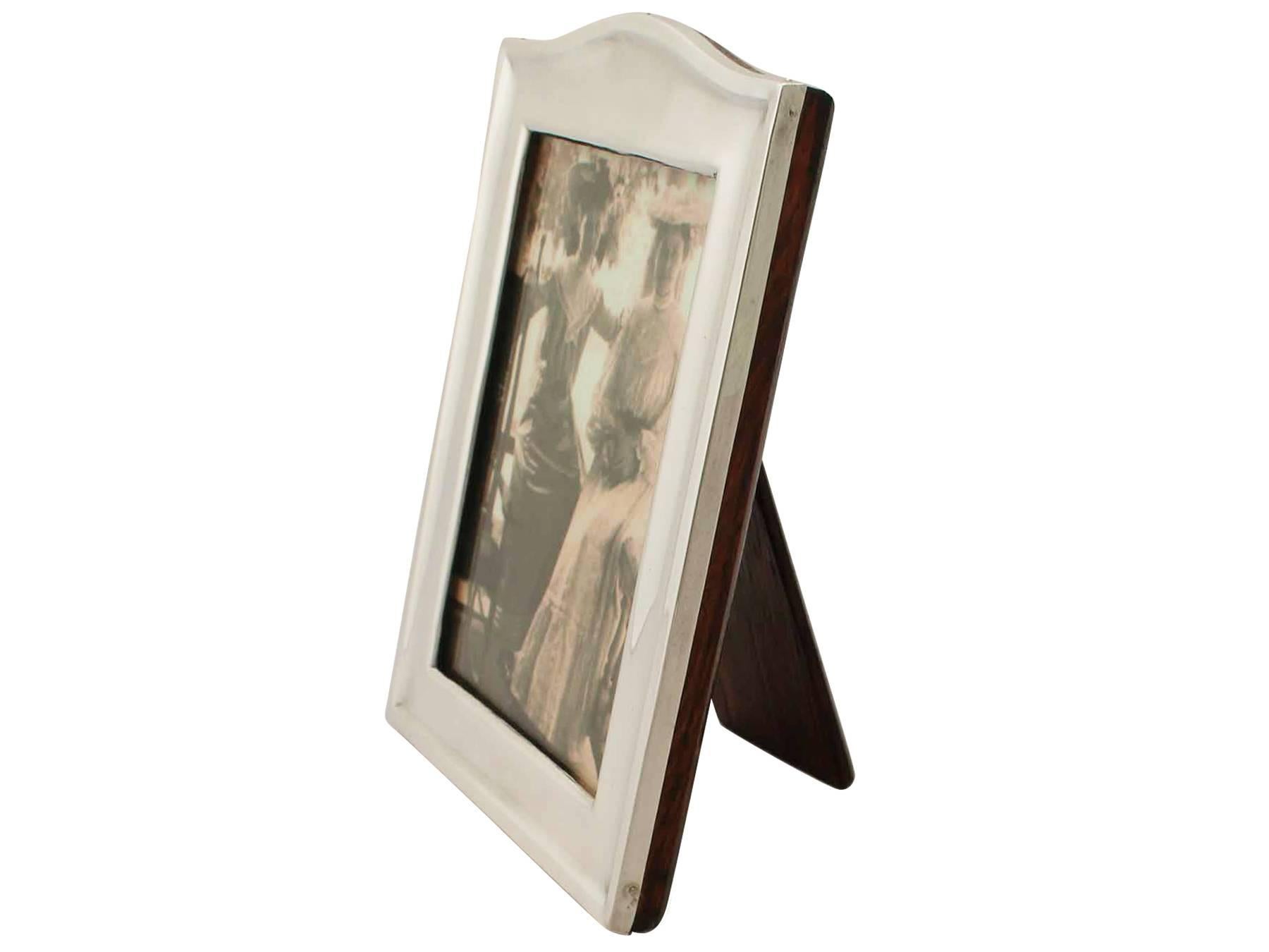 This fine antique George V sterling silver photograph frame has a rectangular form with a domed upper portion and a plain rectangular internal window.

The surface of this antique silver frame is plain and embellished with a paralleling embossed