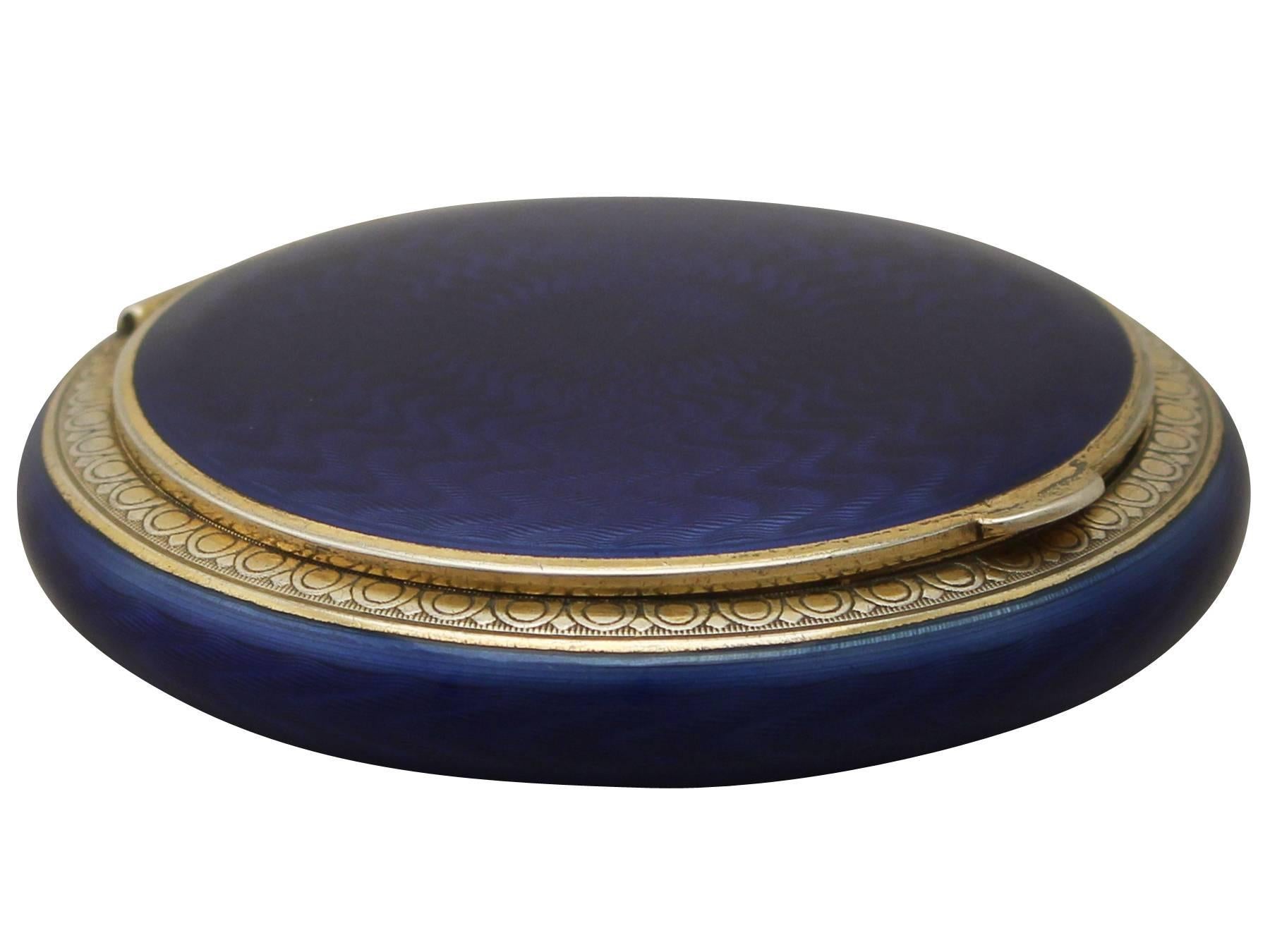 This exceptional antique Norwegian sterling silver gilt and enamel compact has a circular rounded form.

The rounded anterior surface of the body and cover are embellished with blue guilloche enamel, each accented with an impressive gilded silver
