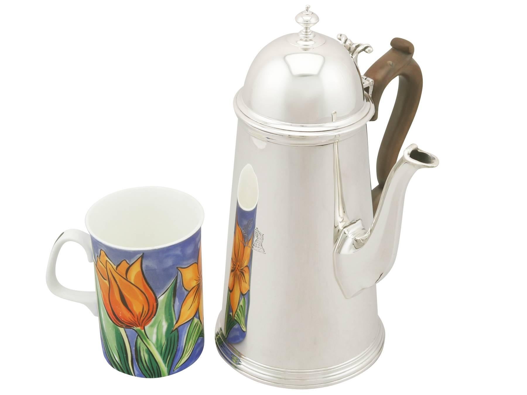 This exceptional antique Edwardian sterling silver coffee pot has a plain tapering cylindrical form on to a circular collet foot, all in the classic George I style.

The surface of this fine example of Edwardian silverware is plain and embellished