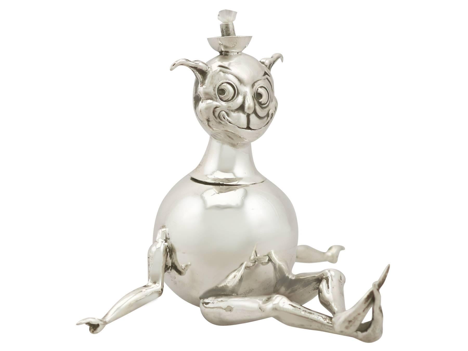 An exceptional, fine and impressive antique George V English sterling silver cigarette/cigar table lighter modelled in the form of a grotesque figure; an addition to our smoking related silverware collection

This exceptional antique George V