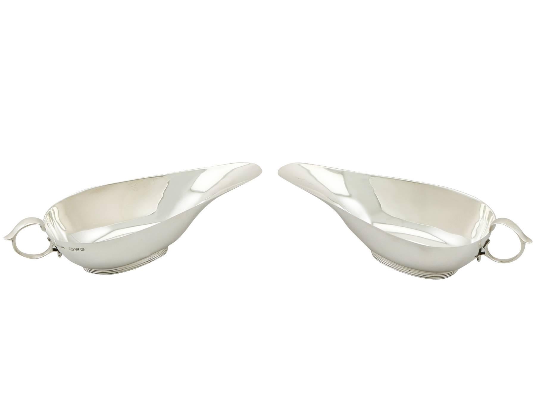 These fine antique George V sterling silver gravy boats have a plain rounded boat shaped form onto a ribbed oval foot.

The body of each piece is plain and unembellished.

These 1930s silver gravy boats are fitted with fine and impressive sterling