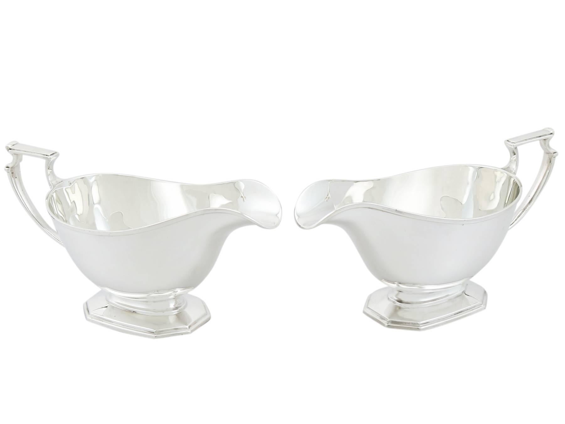 An exceptional, fine and impressive pair of antique George V sterling silver sauceboats made in the Art Deco style; an addition to our dining silverware collection.

These exceptional antique George V sterling silver sauceboats have a plain