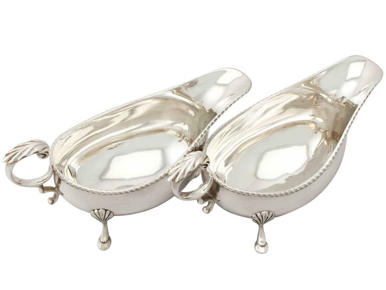 A fine pair of vintage Elizabeth II English sterling silver sauceboats; part of our ornamental dining silverware collection.

These vintage Elizabeth II sterling silver sauceboats have a plain oval boat shaped form.

The body of each vintage