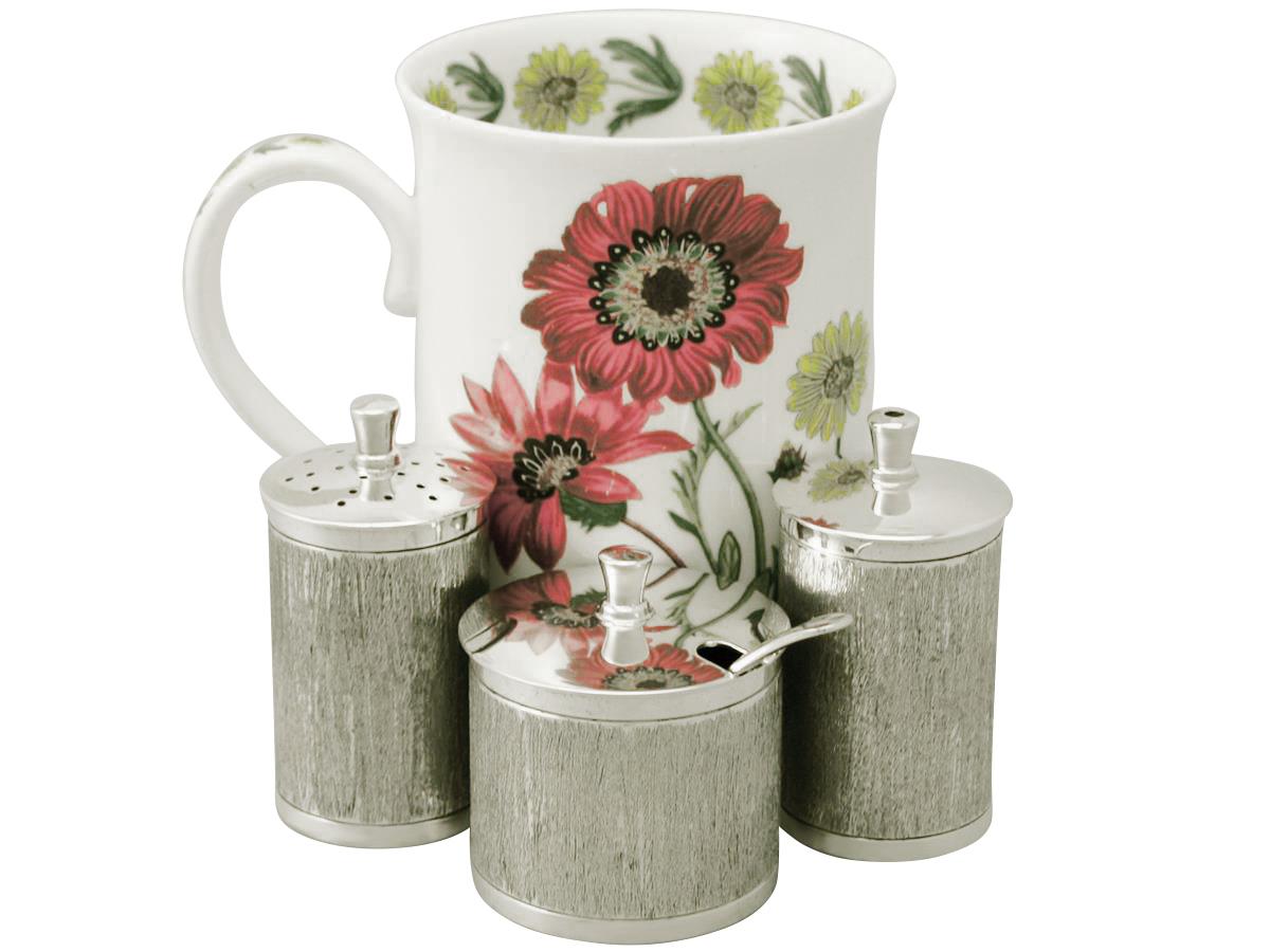This fine vintage Elizabeth II English sterling silver three-piece condiment set consists of a salt pot, a pepper pot and a mustard pot.

Each piece has a cylindrical form onto a collet shaped foot.

The surface of each piece is embellished with