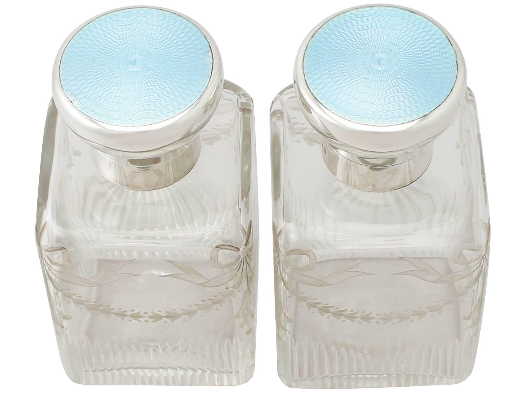 A fine and impressive pair of large antique George V English sterling silver, glass and enamel cologne bottles; an addition to our silver mounted glass collection.

These fine George V cut and etched glass antique cologne bottles have a cuboid form