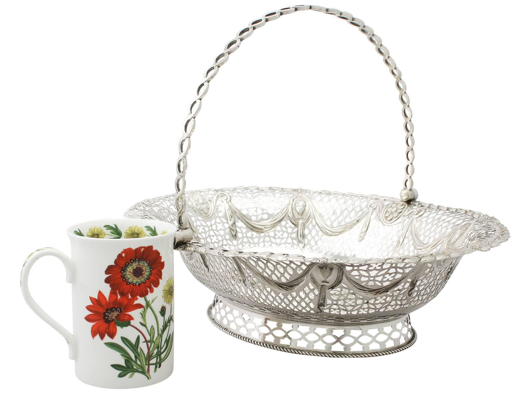 A fine and impressive antique Georgian English sterling silver swing handled cake basket; an addition to our dining silverware collection

This impressive George III sterling silver cake basket has an oval rounded form onto a collet style