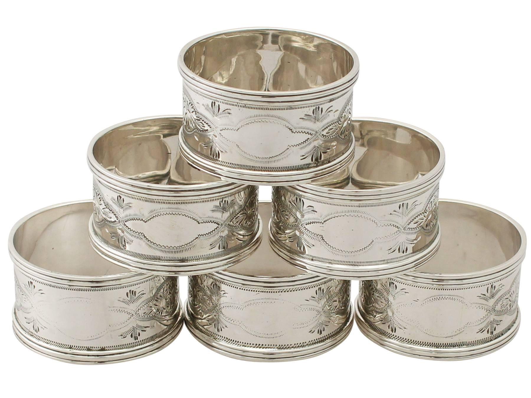 An exceptional, fine and impressive set of six antique George V English sterling silver napkin rings - boxed; an addition to our dining silverware collection

The surface of each napkin ring is encircled with impressive bright cut engraved