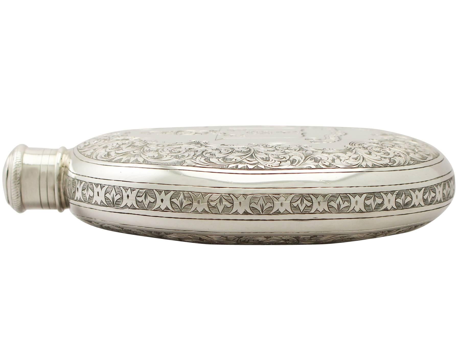A magnificent, fine and impressive, large antique Victorian English sterling silver hip flask; an addition to our wine and drinks related silverware collection.

This magnificent antique Victorian sterling silver hip flask has a plain oval rounded