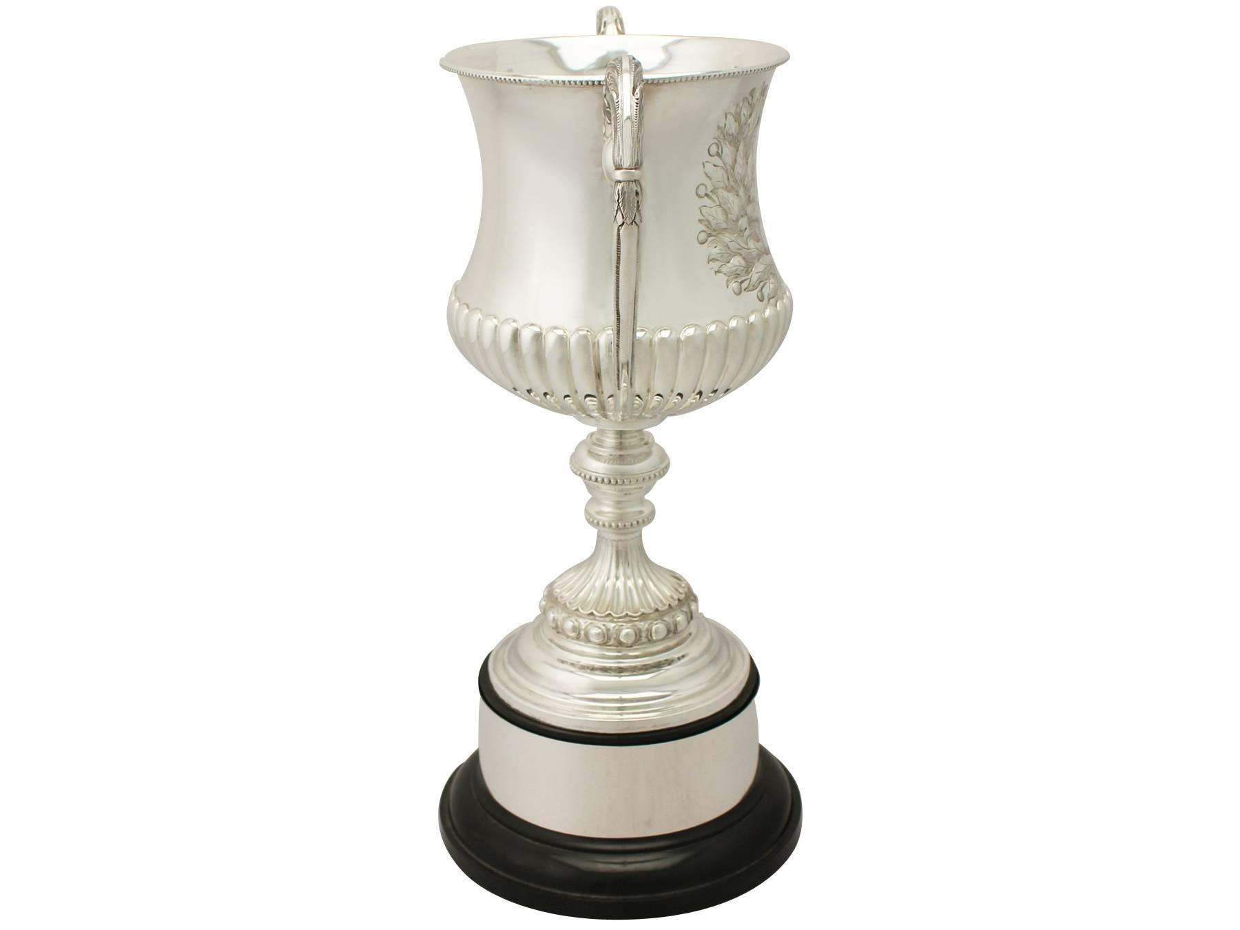 A fine and impressive antique Victorian English sterling silver presentation cup; an addition to our presentation silverware collection.

This fine antique Victorian sterling silver presentation cup has a Campania shaped form to a knopped pedestal
