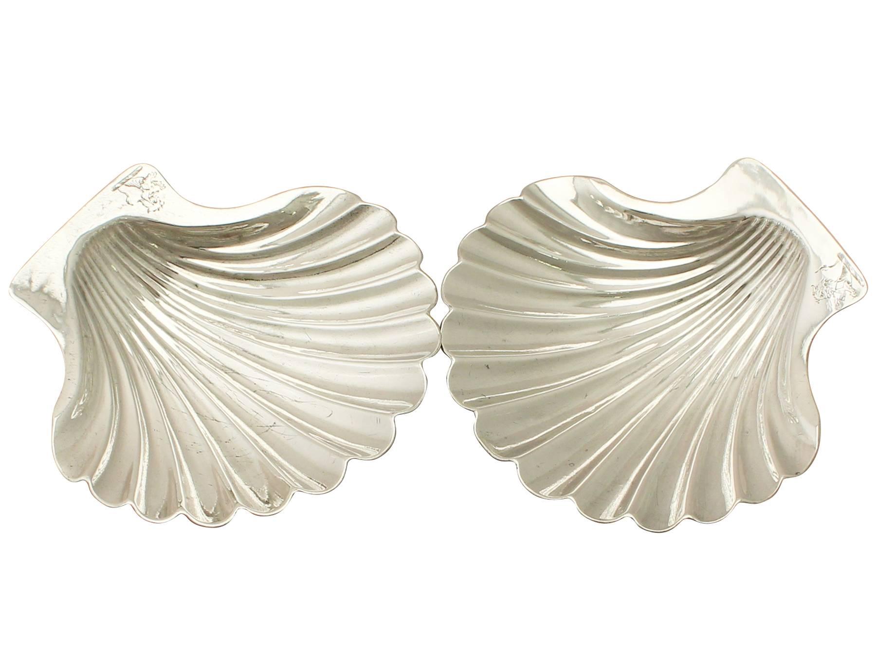A fine and impressive pair of antique Georgian English sterling silver butter shells/dishes; an addition to our dining silverware collection.

These fine antique George III sterling silver butter dishes have a plain scallop shell shaped