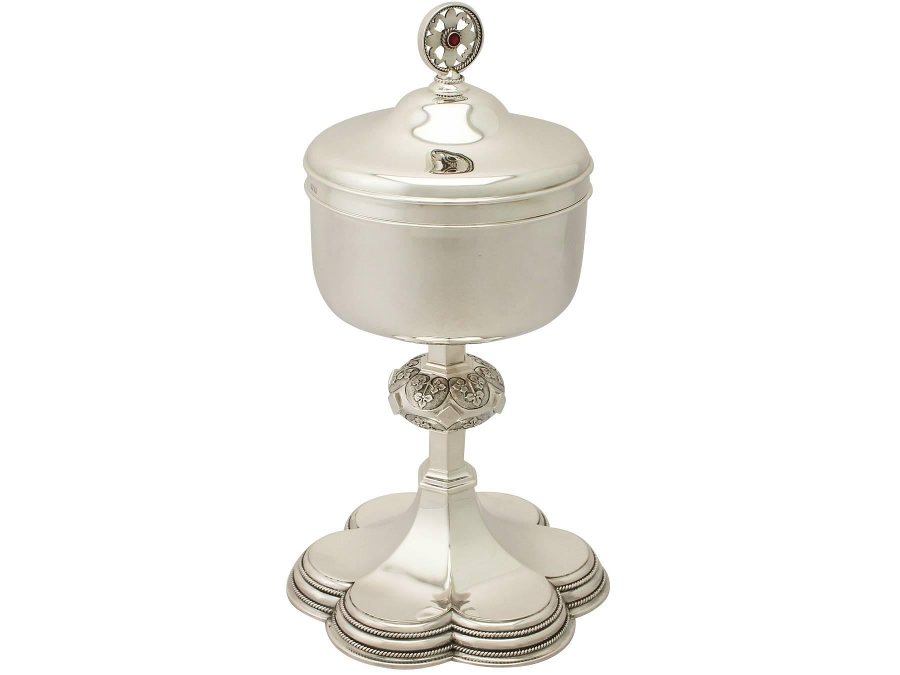 This exceptional vintage Elizabeth II sterling silver ciborium*/ecclesiastical chalice has a circular rounded form onto a circular knop and tapering panelled pedestal to a hexafoil shaped foot.

The surface of this vintage ciborium is plain and