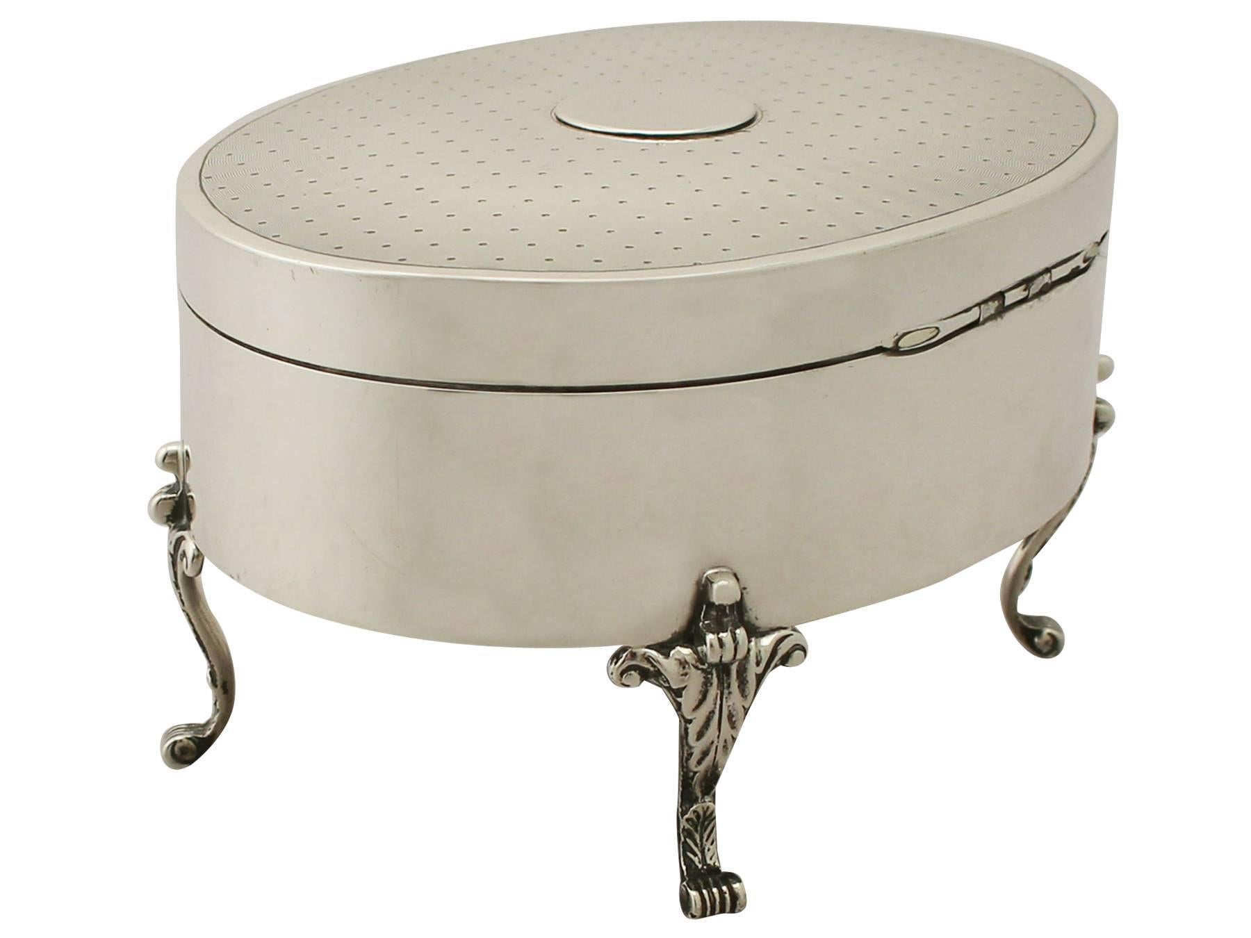 A fine and impressive antique George V English sterling silver jewelry/trinket box; an addition to our ornamental silverware collection.

This exceptional antique George V sterling silver trinket box has a plain oval form.

The body of this